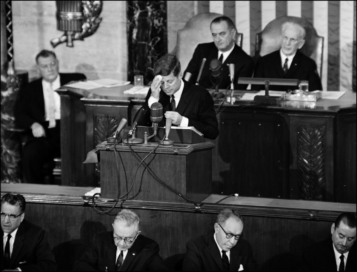 US President John F. Kennedy (C) wipes his forehea