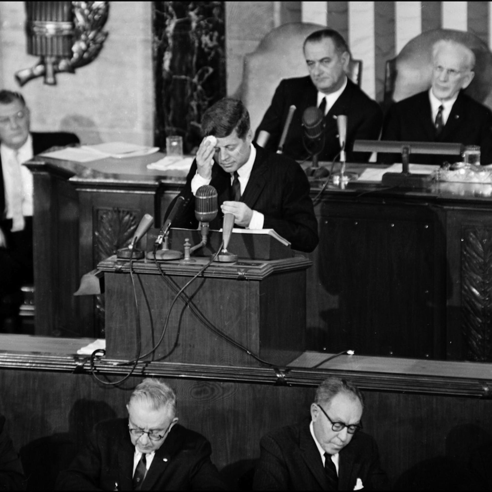 US President John F. Kennedy (C) wipes his forehea
