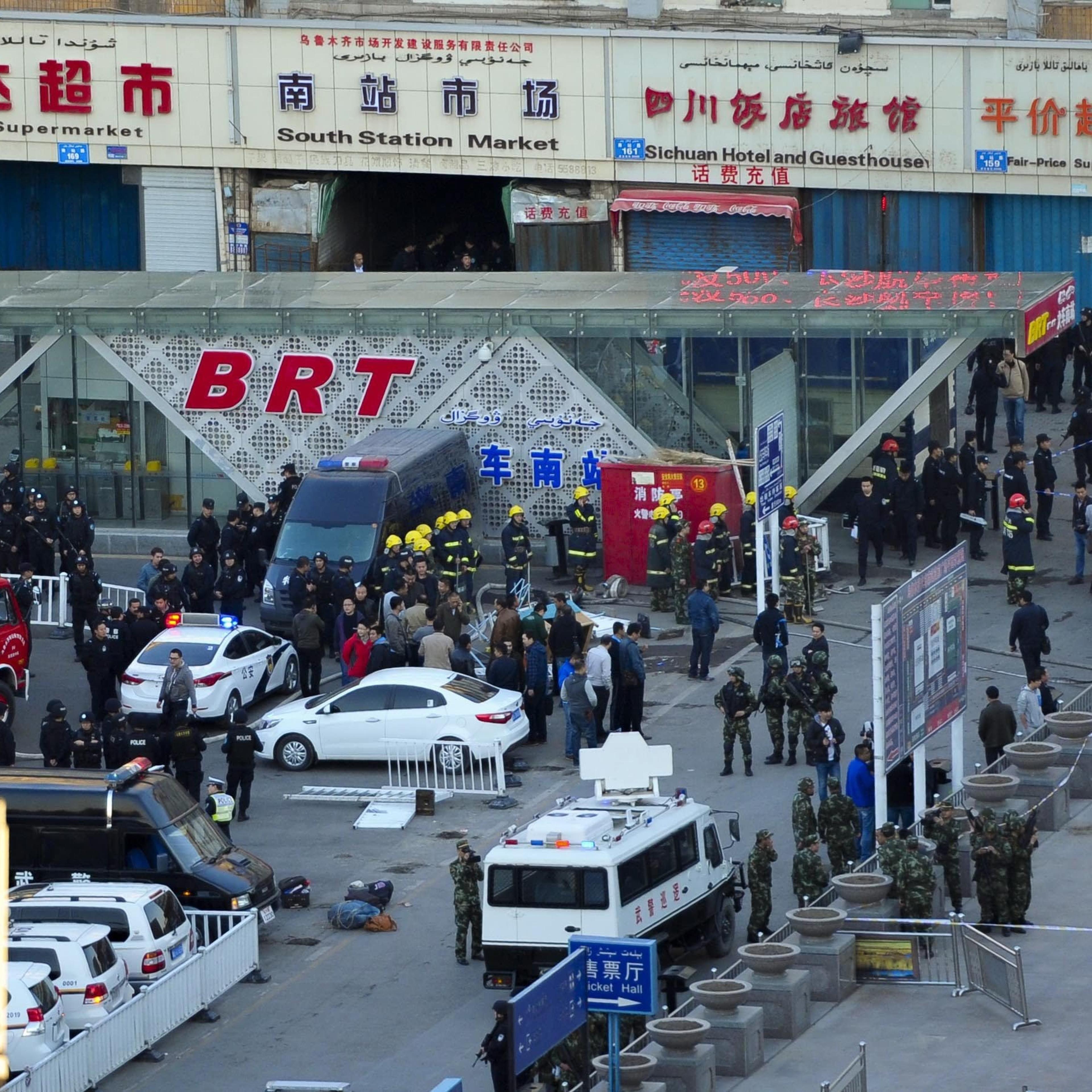 Security personnel inspect the explosion site outside Urumqi South Railway Station in Urumqi in northwest China's Xinjiang Uygur Autonomous Region, April 30, 2014 after an explosion that killed some people and injured some.