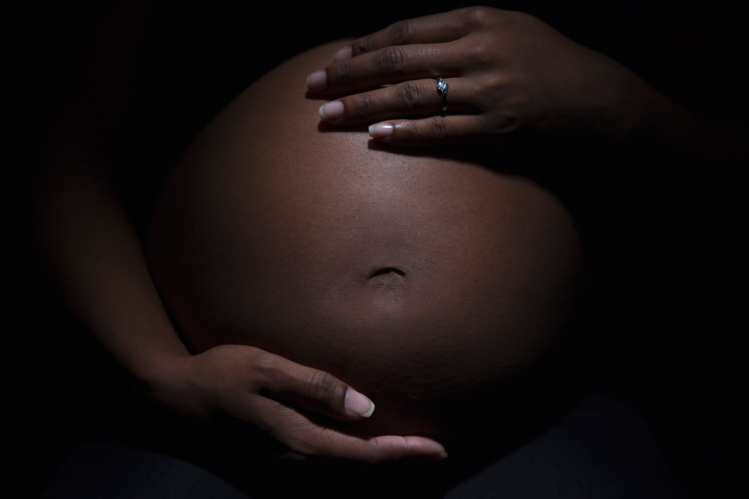 Close up of mixed race woman's pregnant stomach