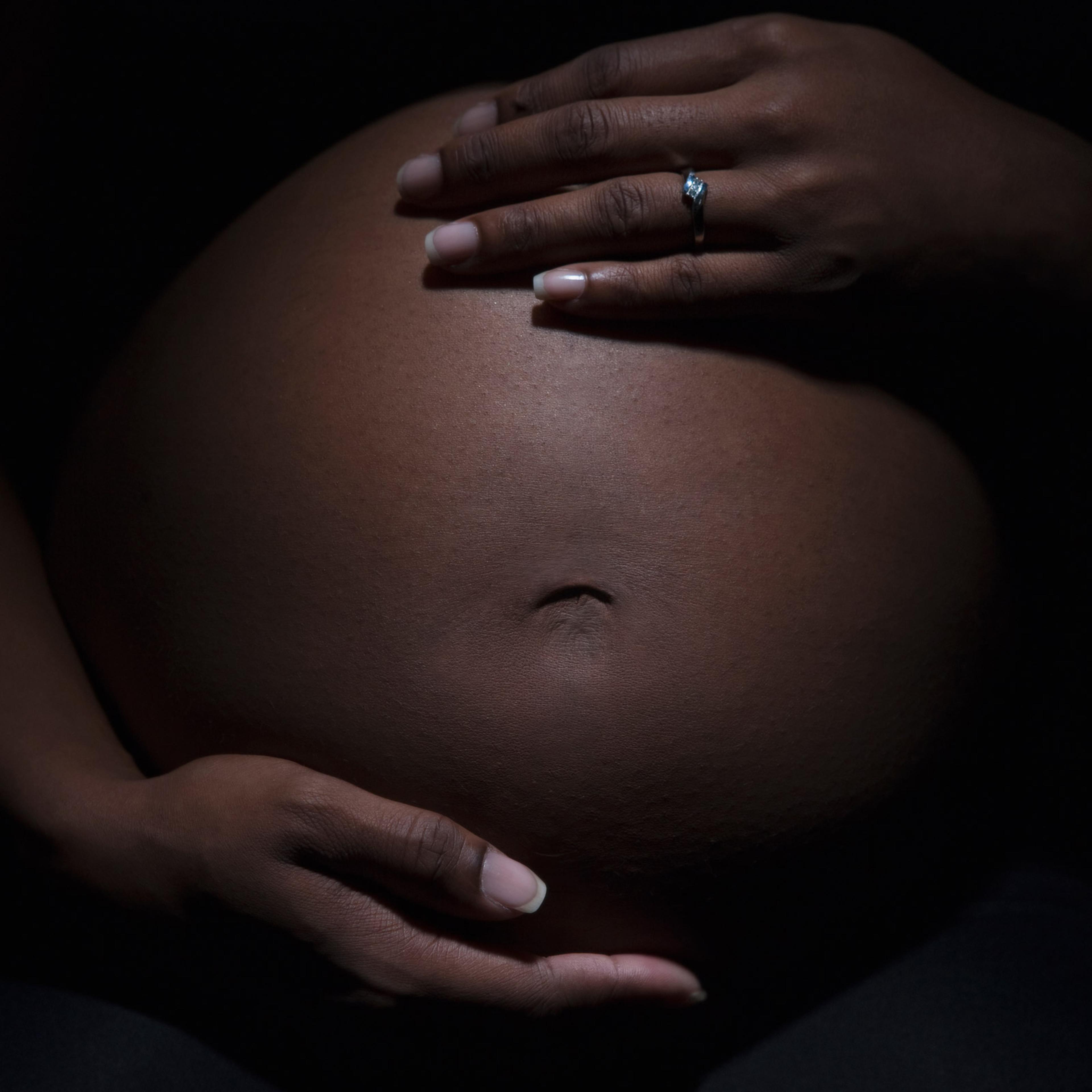 Close up of mixed race woman's pregnant stomach