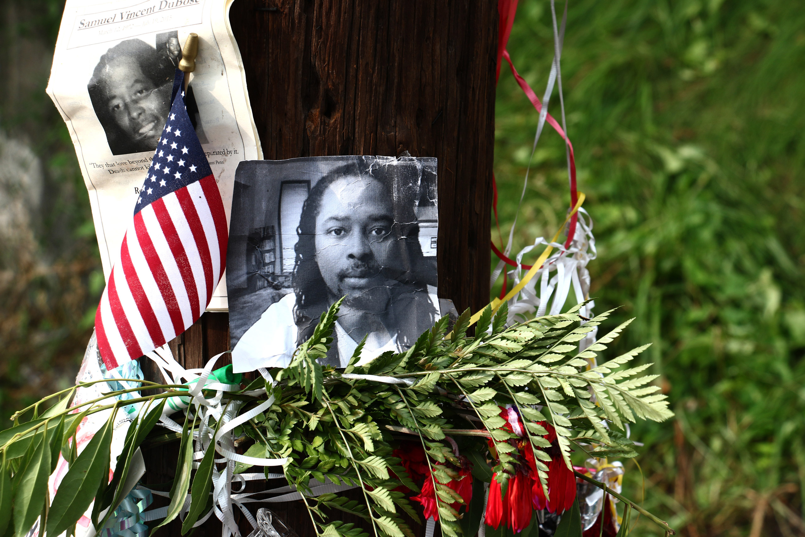 FILE - In this July 29 2015 file photo, photos of Samuel DuBose hang on a pole at a memorial in Cincinnati, near where he was shot and killed by a University of Cincinnati police officer. The estate of DuBose will be managed by his 18-year-old daughter, 