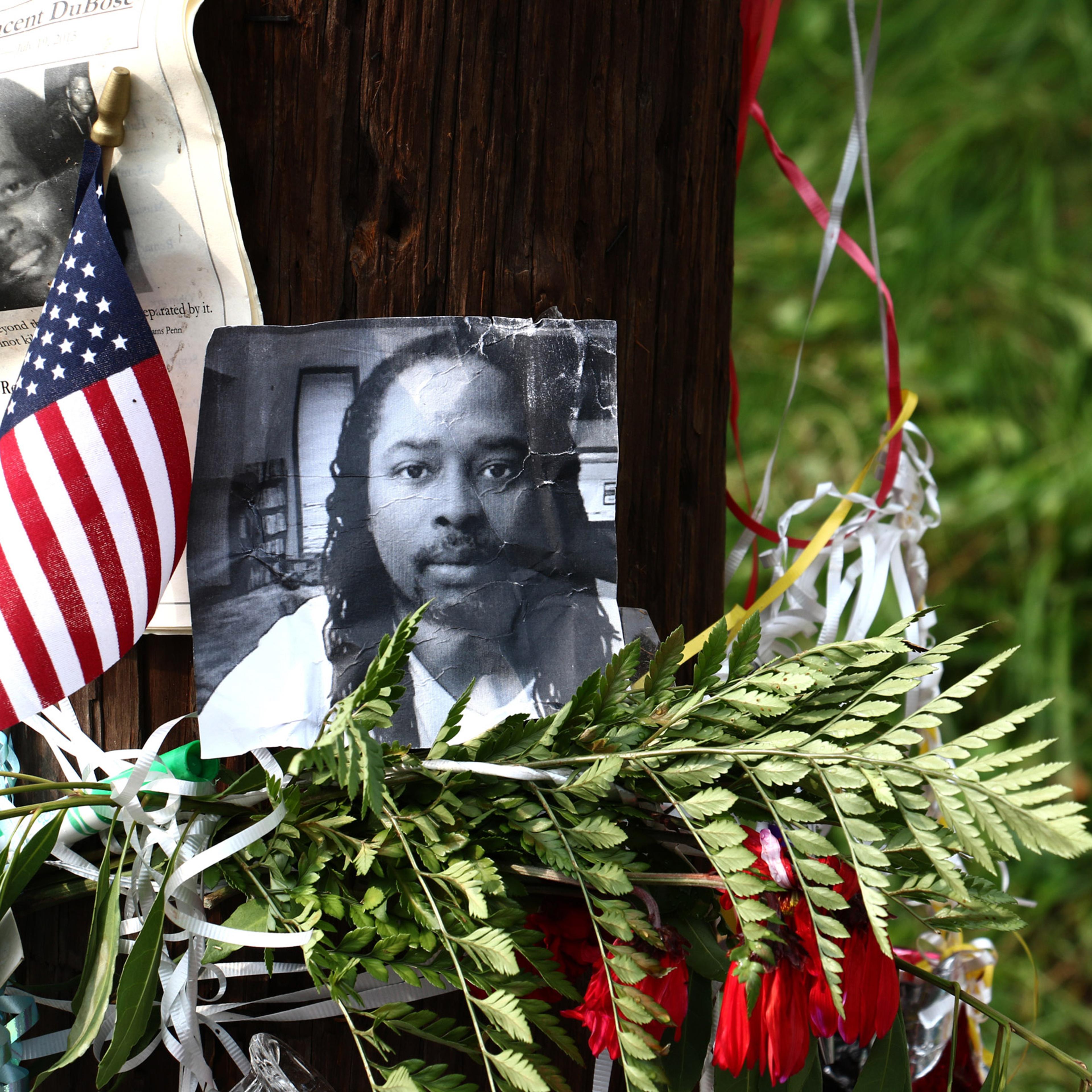 FILE - In this July 29 2015 file photo, photos of Samuel DuBose hang on a pole at a memorial in Cincinnati, near where he was shot and killed by a University of Cincinnati police officer. The estate of DuBose will be managed by his 18-year-old daughter,