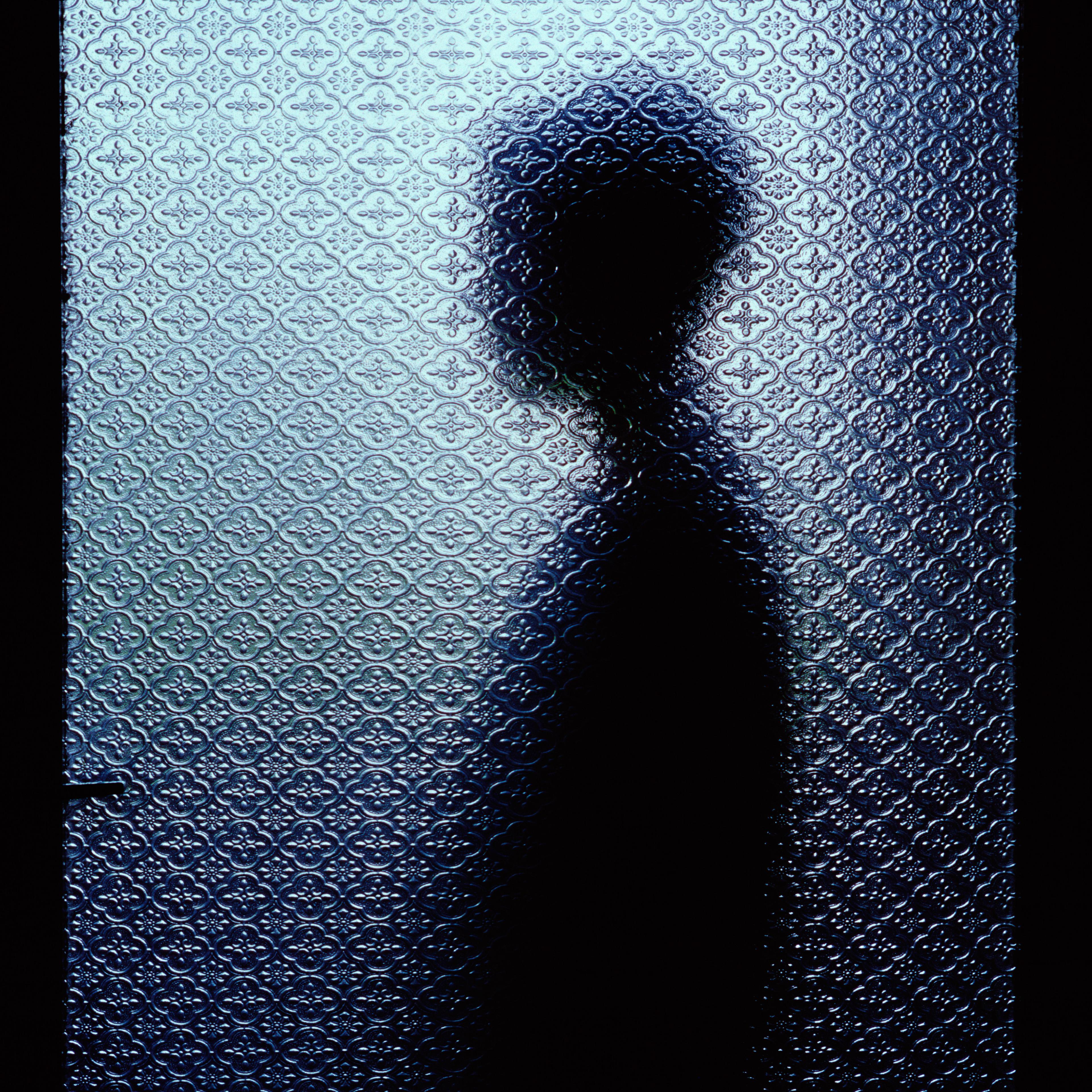 Silhouetted man through window