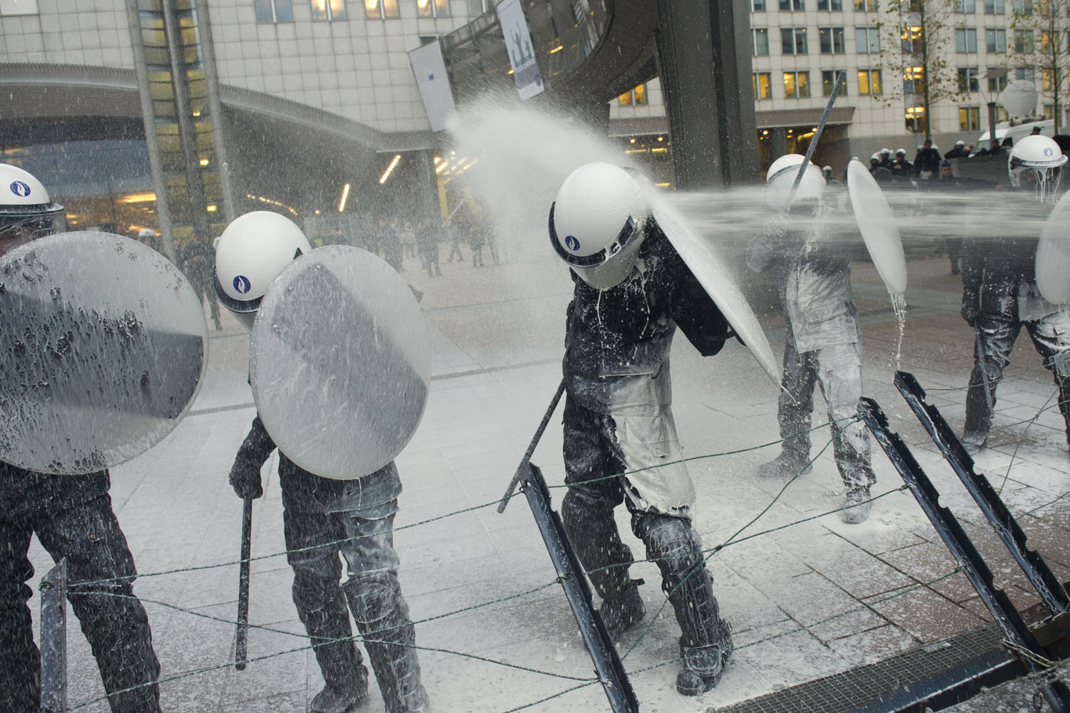 Nov. 26, 2012. Police officers are sprayed with milk by European milk farmers during a demonstration outside the European Parliament in Brussels.