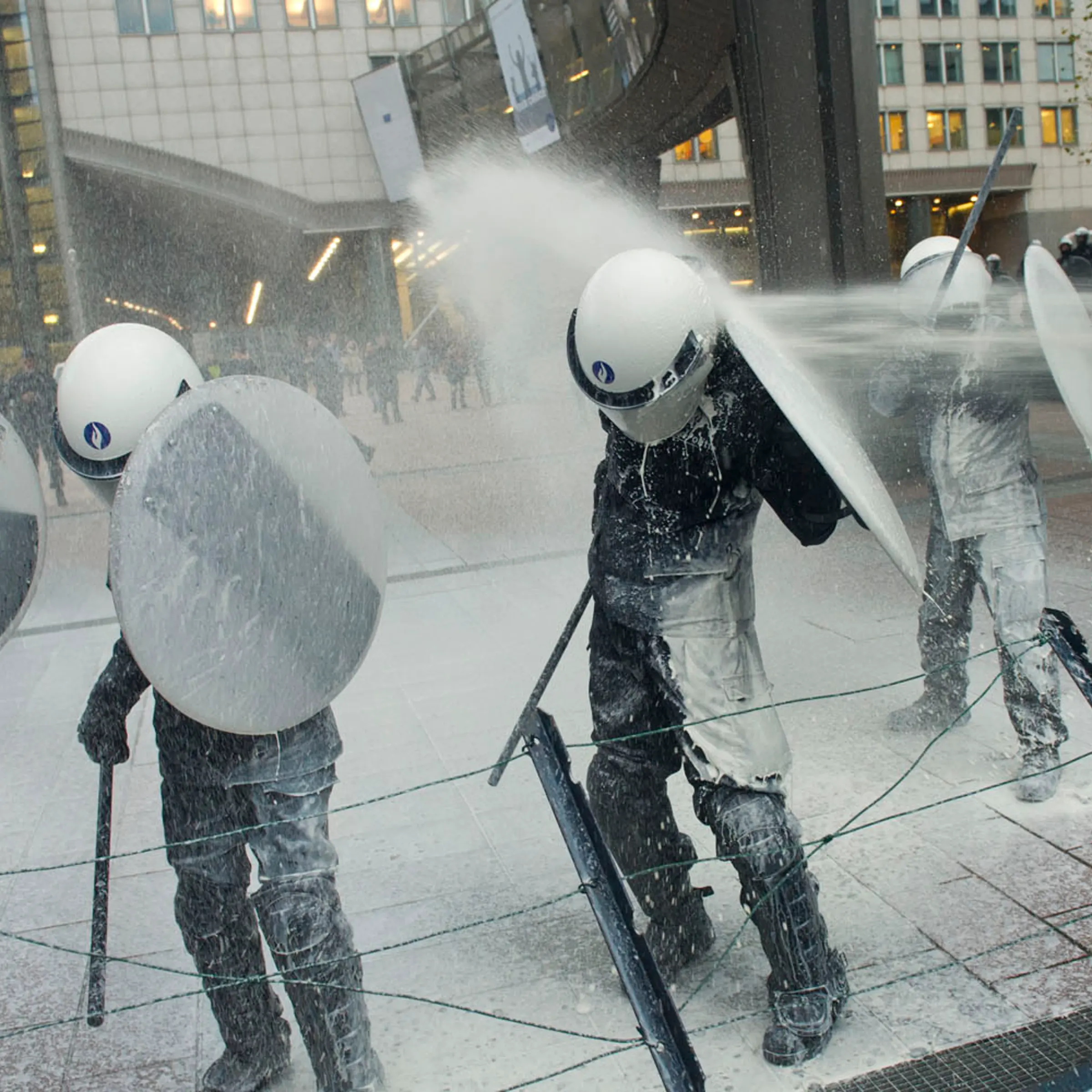 Nov. 26, 2012. Police officers are sprayed with milk by European milk farmers during a demonstration outside the European Parliament in Brussels.