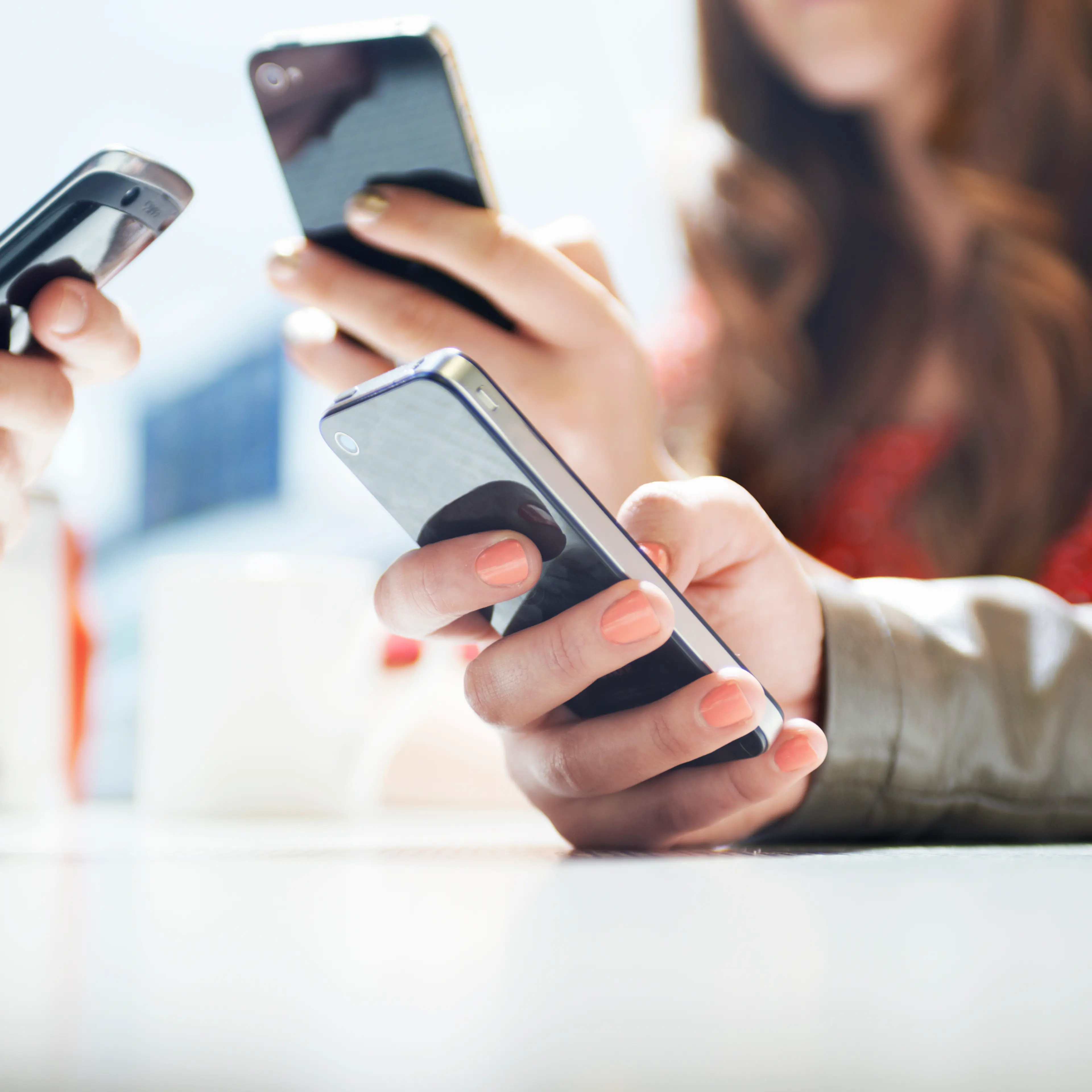 hands texting with mobile phones in cafe