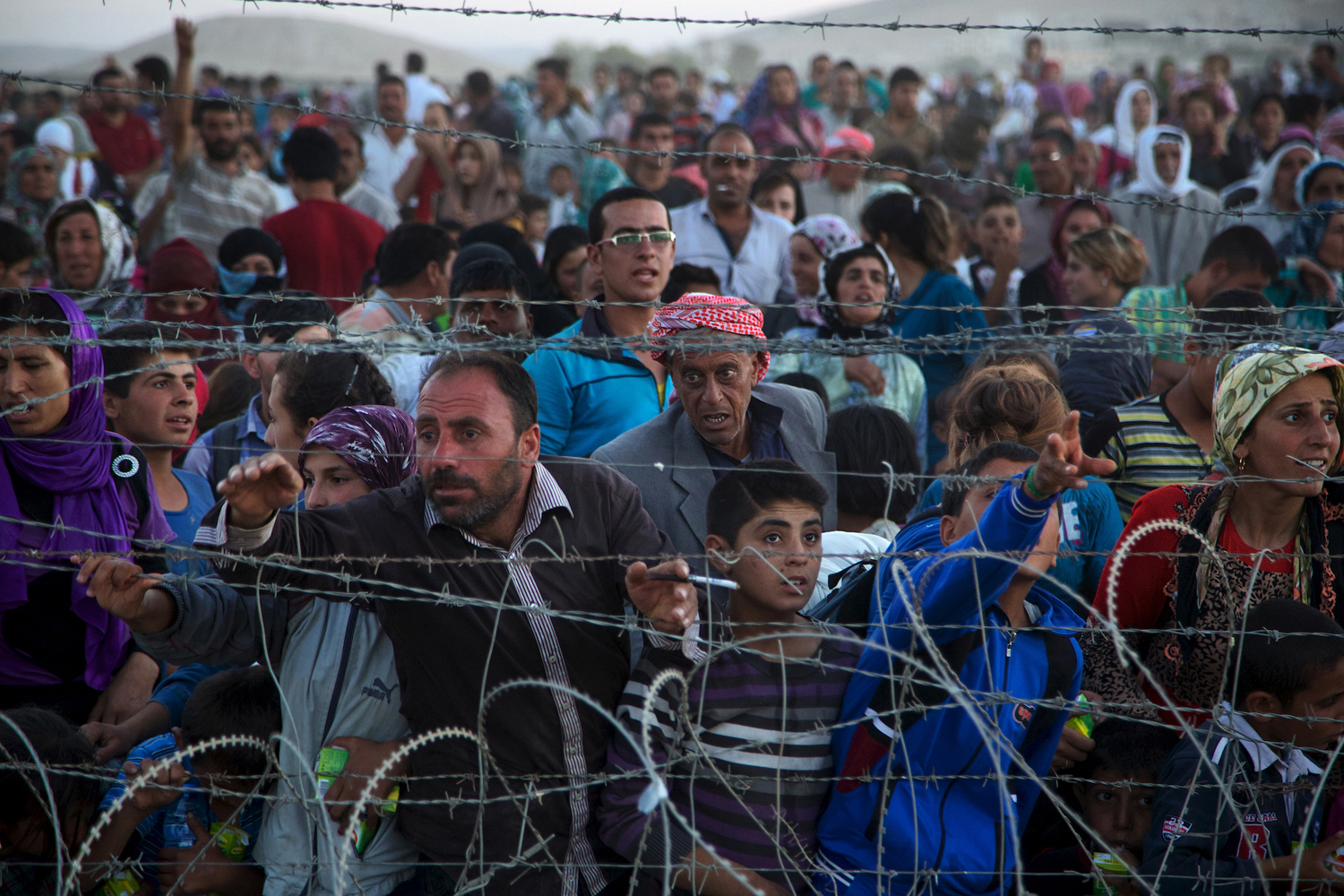 Up to 5,000 Syrians from Kobani amass at the border with Turkey on Friday evening, next to the Turkish village of Dikmetas.