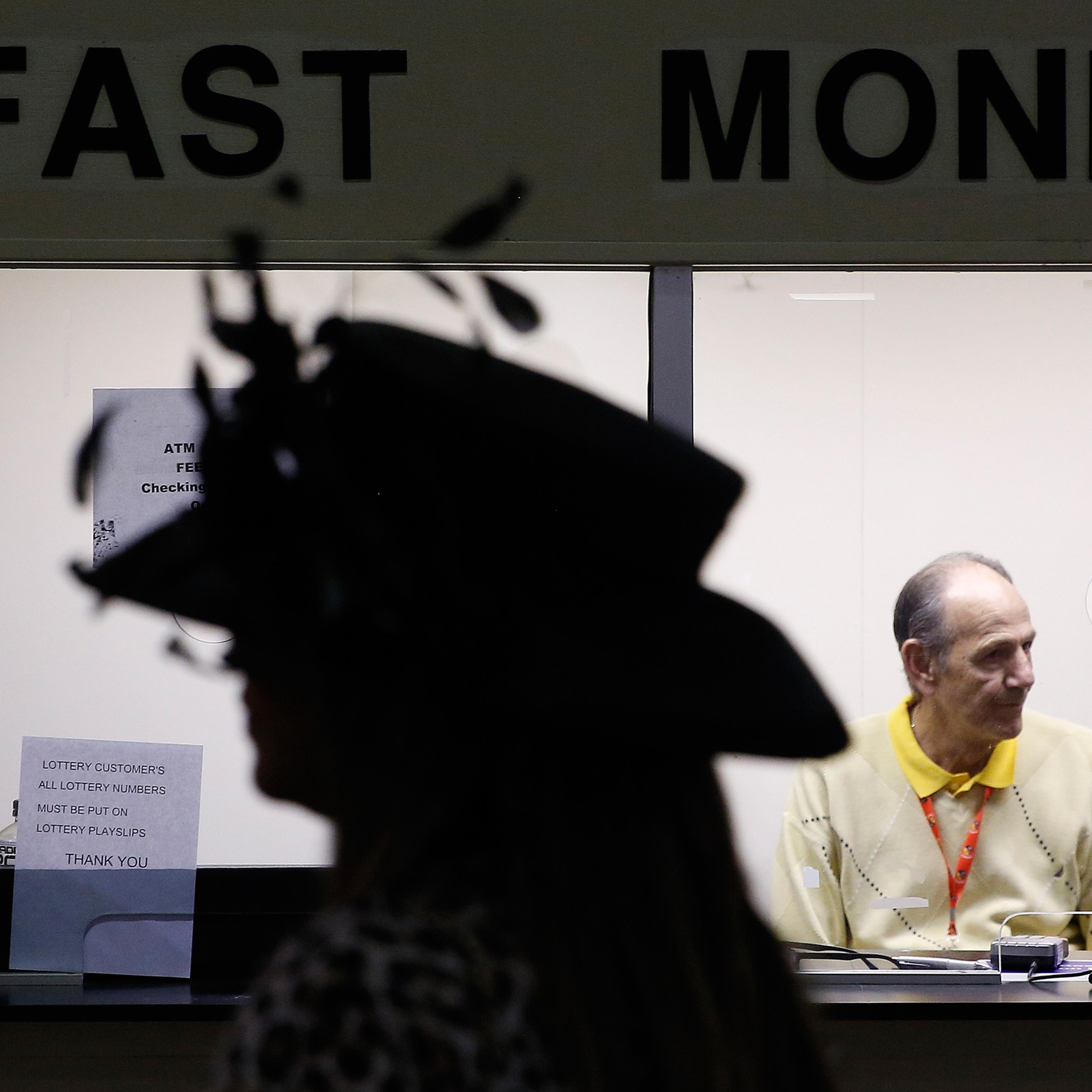 A woman passes a counter ahead of the 141st Preakness Stakes horse race at Pimlico Race Course, Saturday, May 21, 2016, in Baltimore. (AP Photo/Patrick Semansky)