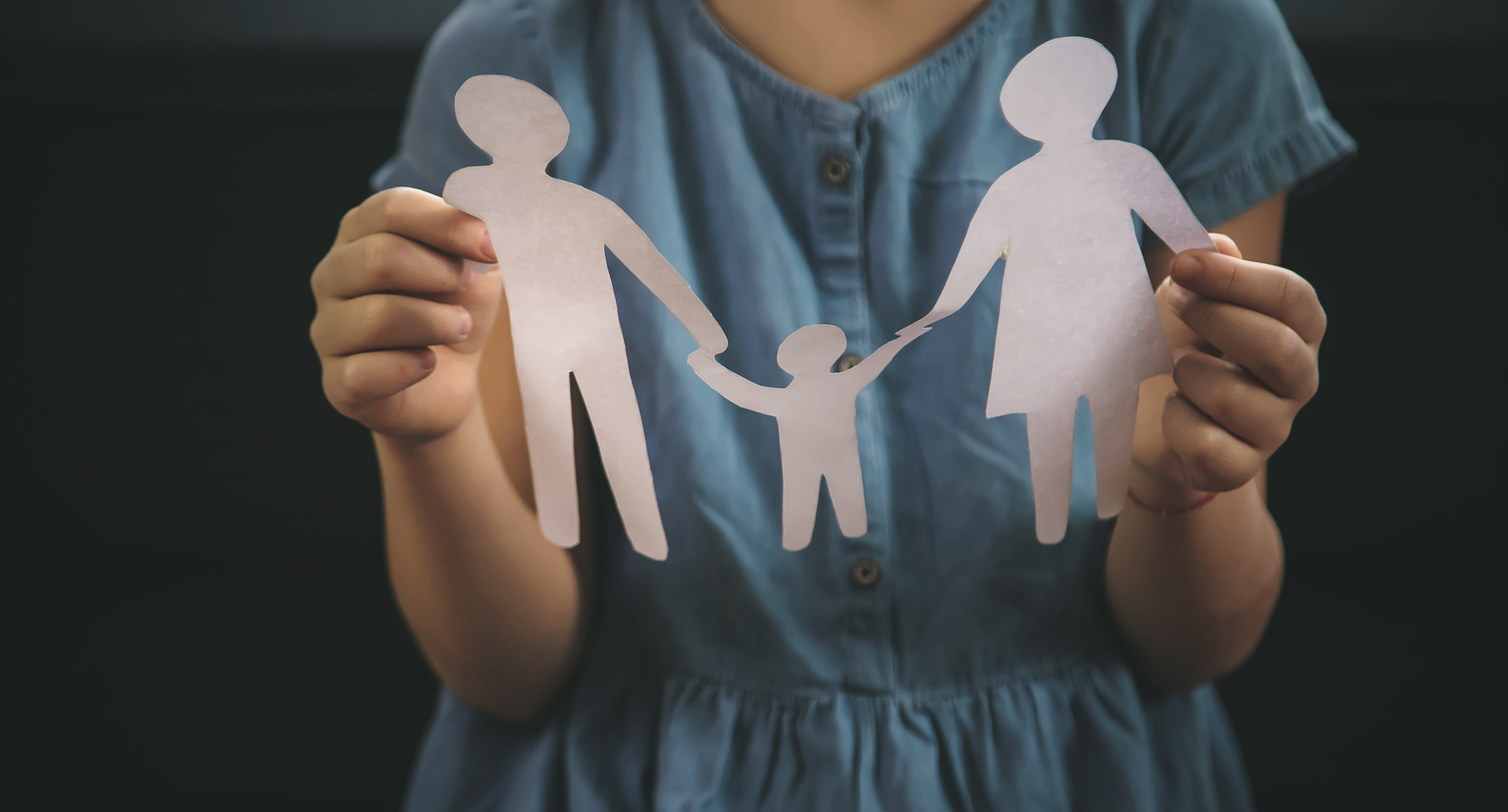 Child with a paper family in her hands
