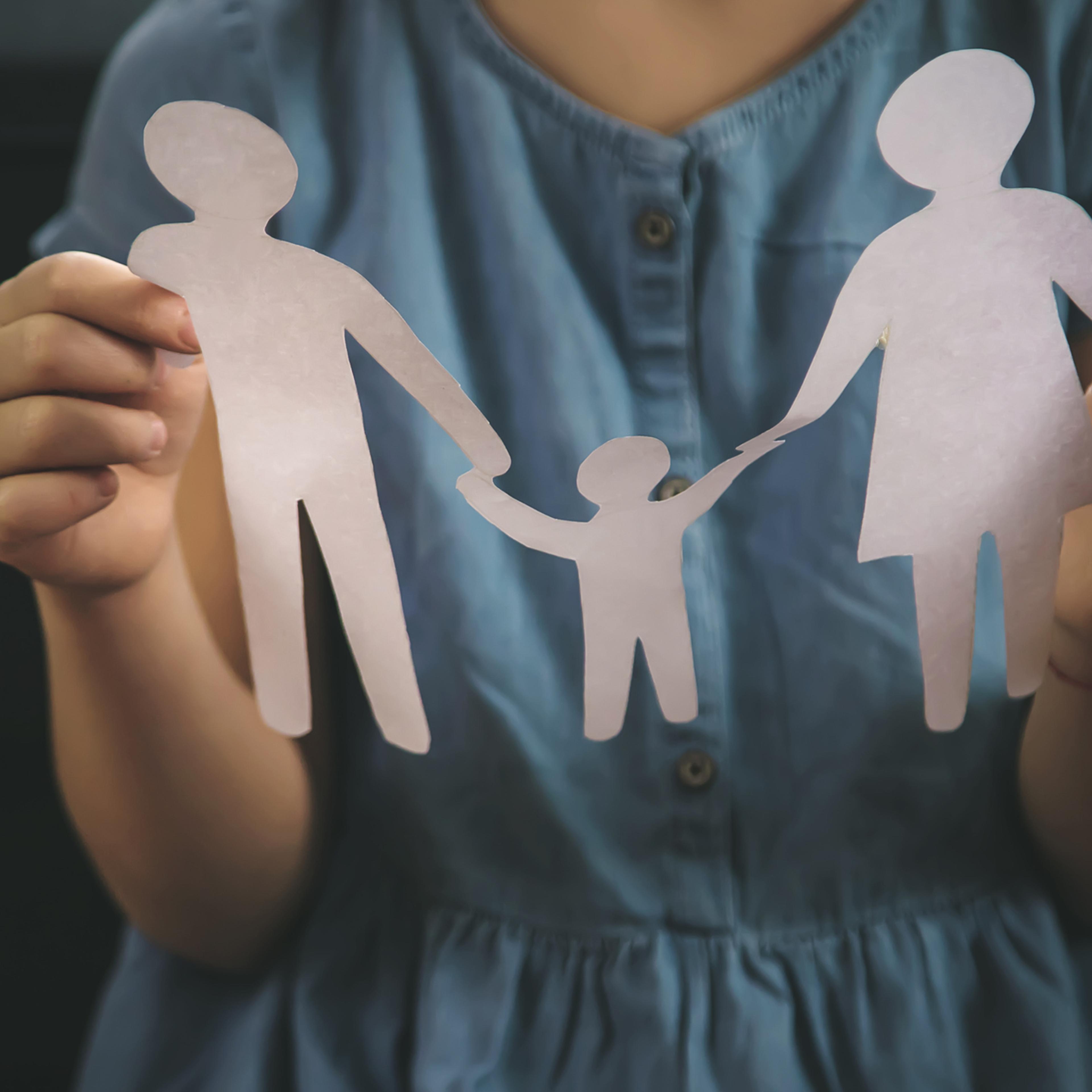 Child with a paper family in her hands