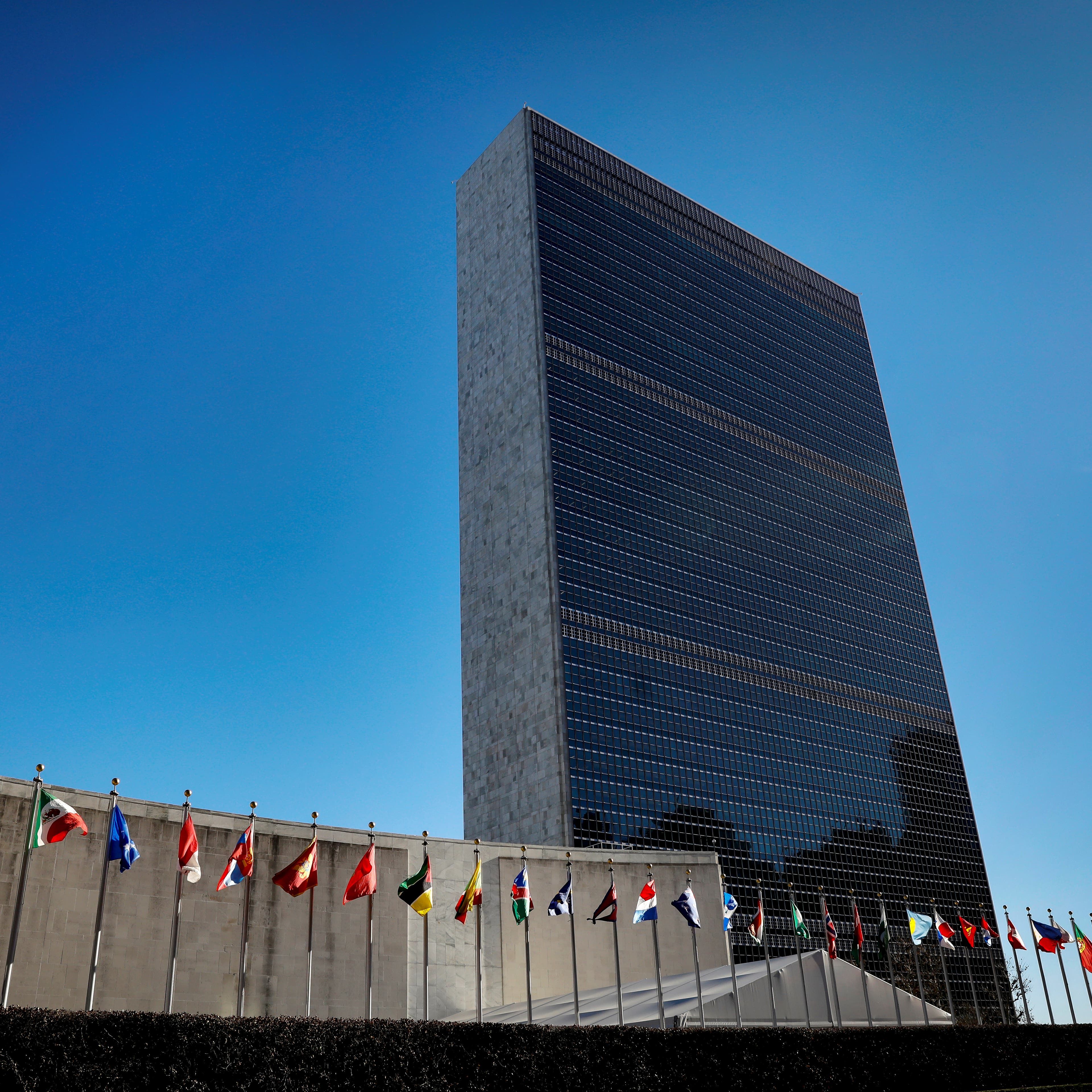 International flags fly in front of The United Nations Headquarters building in New York