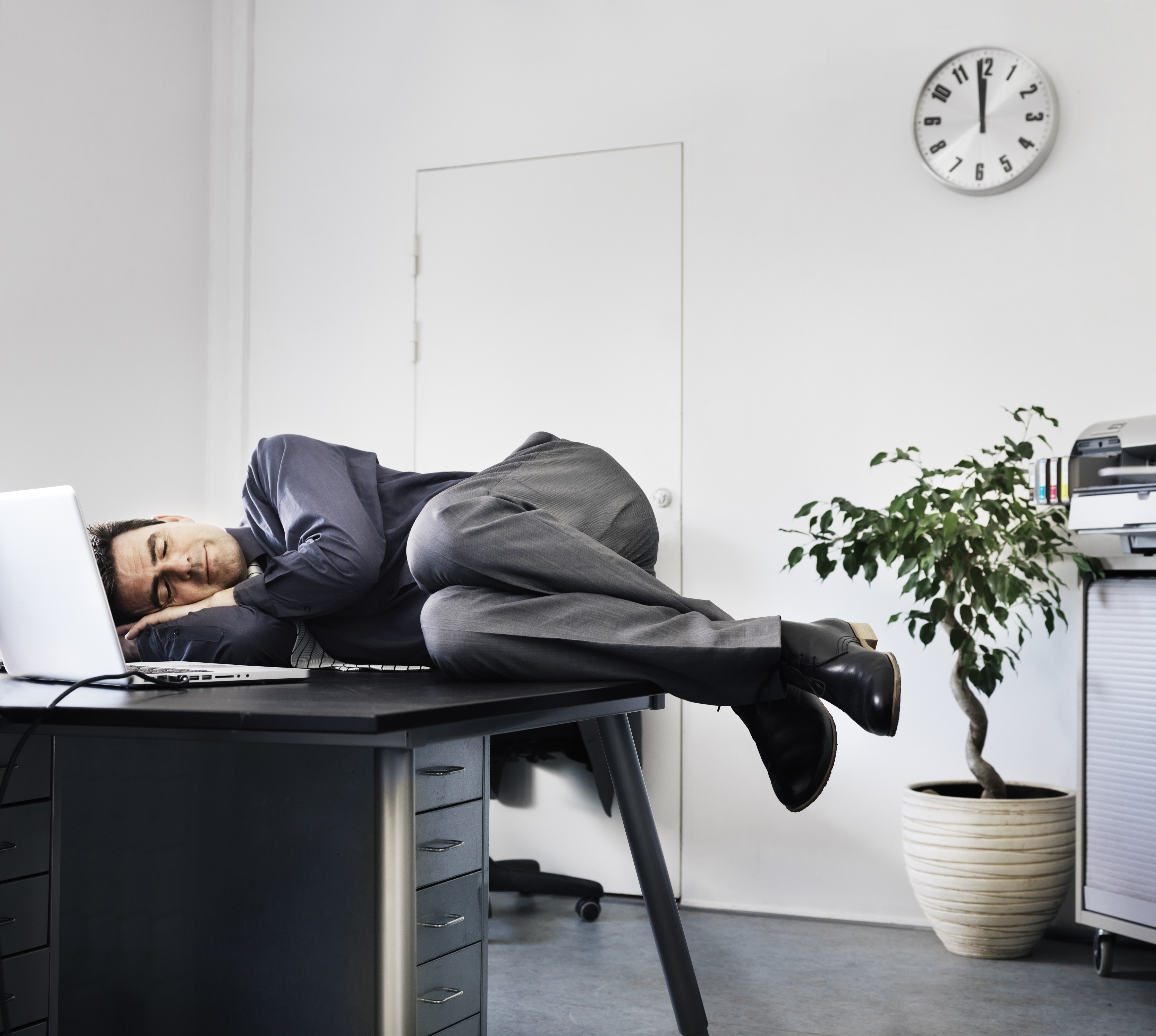 Businessman asleep on his office desk