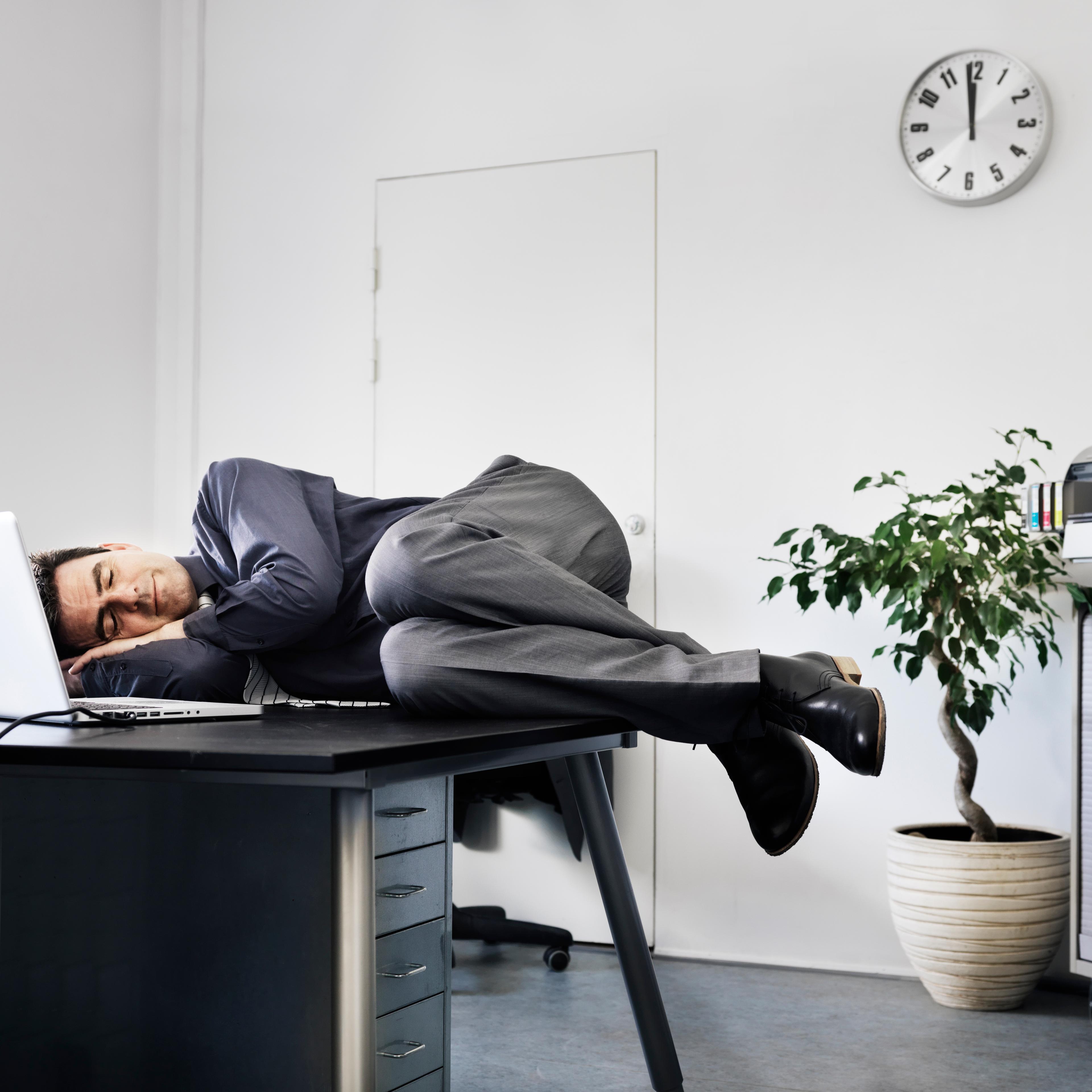 Businessman asleep on his office desk