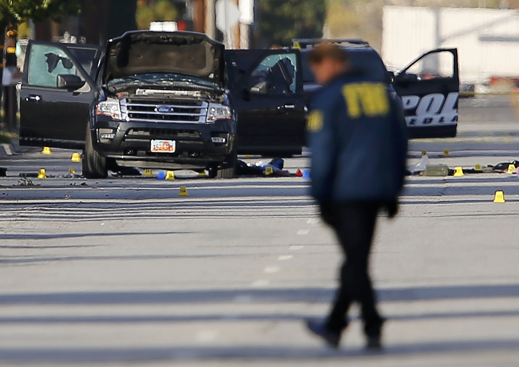 FBI and police continue their investigation around the area of the SUV vehicle where two suspects were shot by police following a mass shooting in San Bernardino, Calif. on Dec. 3, 2015.