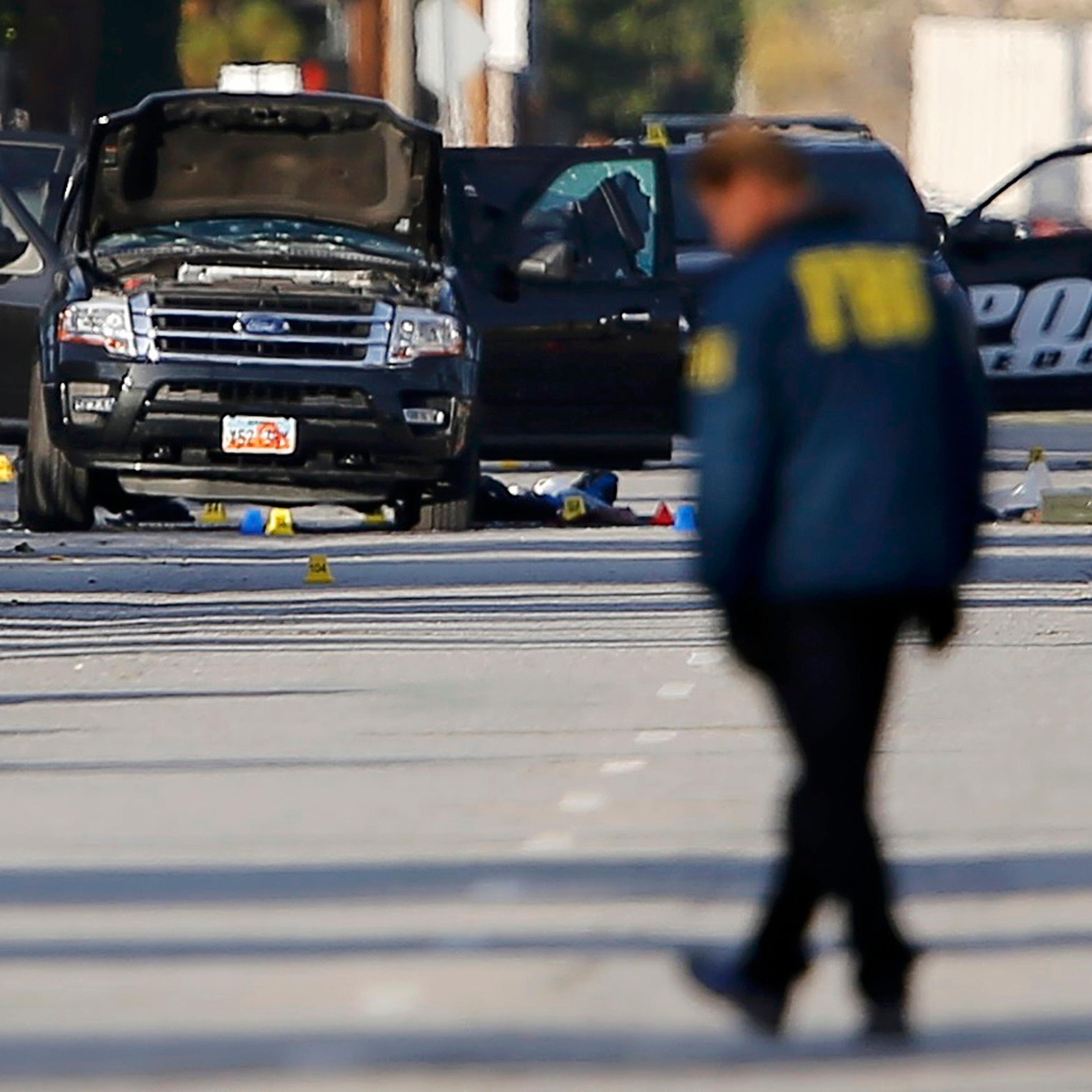 FBI and police continue their investigation around the area of the SUV vehicle where two suspects were shot by police following a mass shooting in San Bernardino, Calif. on Dec. 3, 2015.