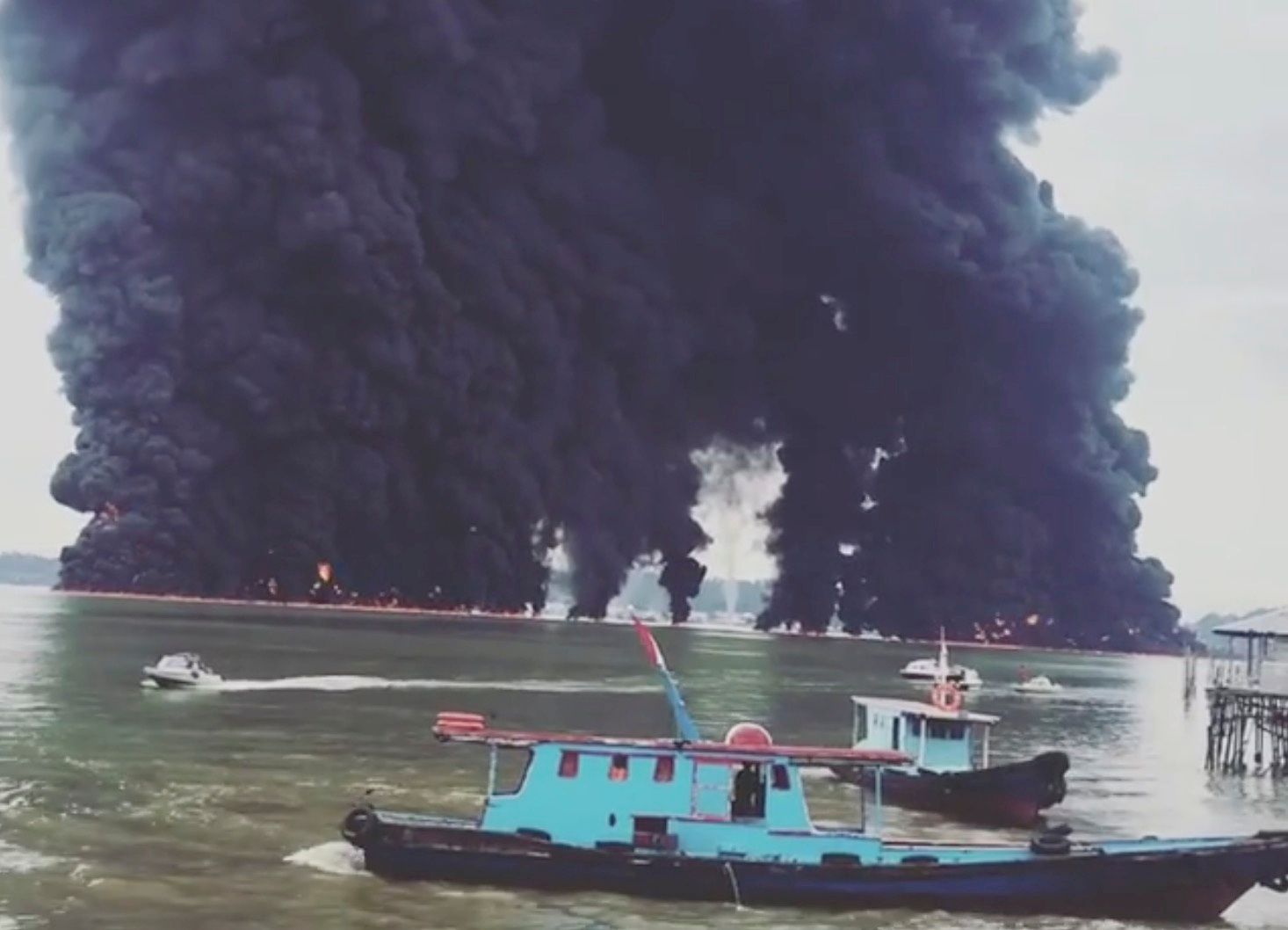 Thick plumes of smoke rise from fire at the sea near Balikpapan