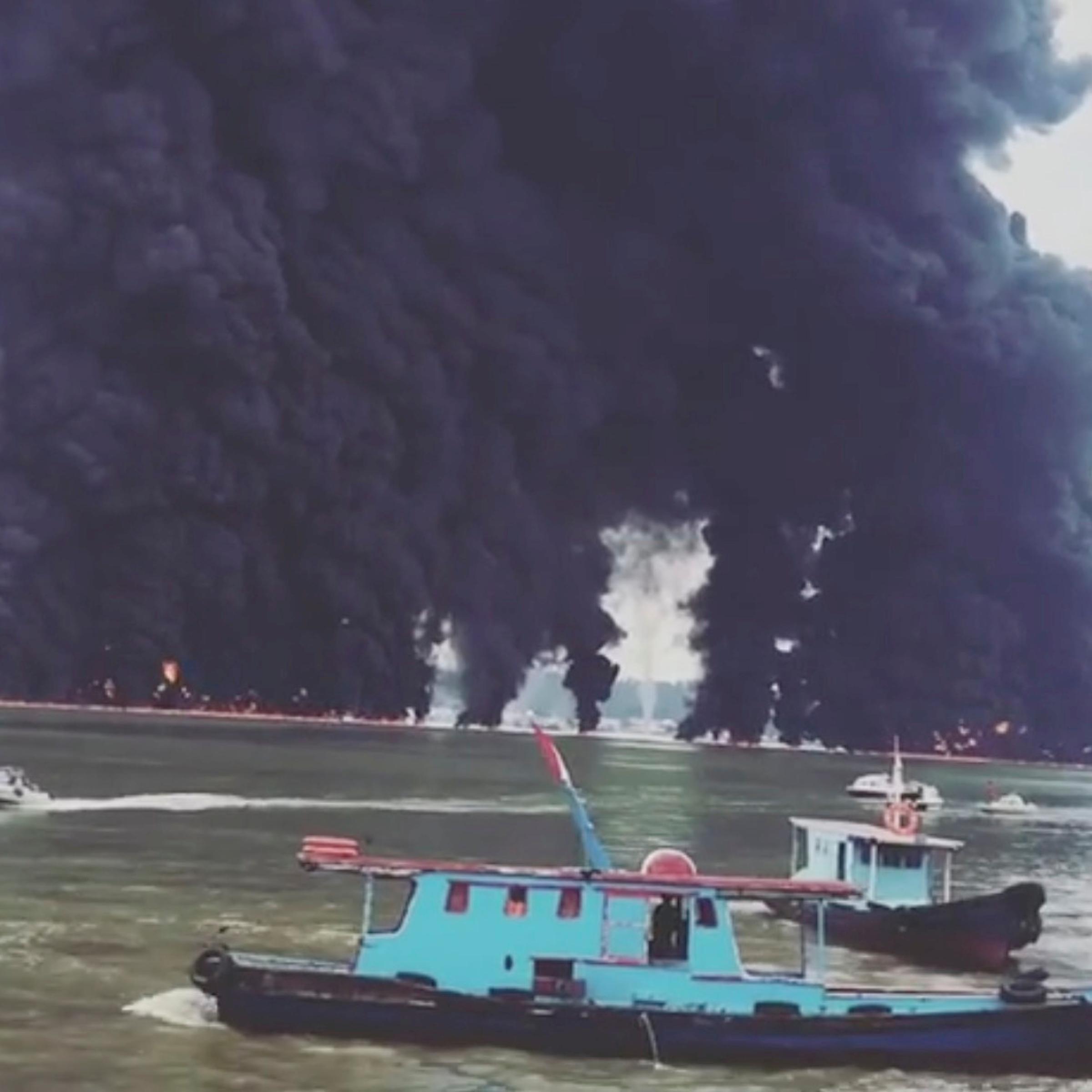 Thick plumes of smoke rise from fire at the sea near Balikpapan
