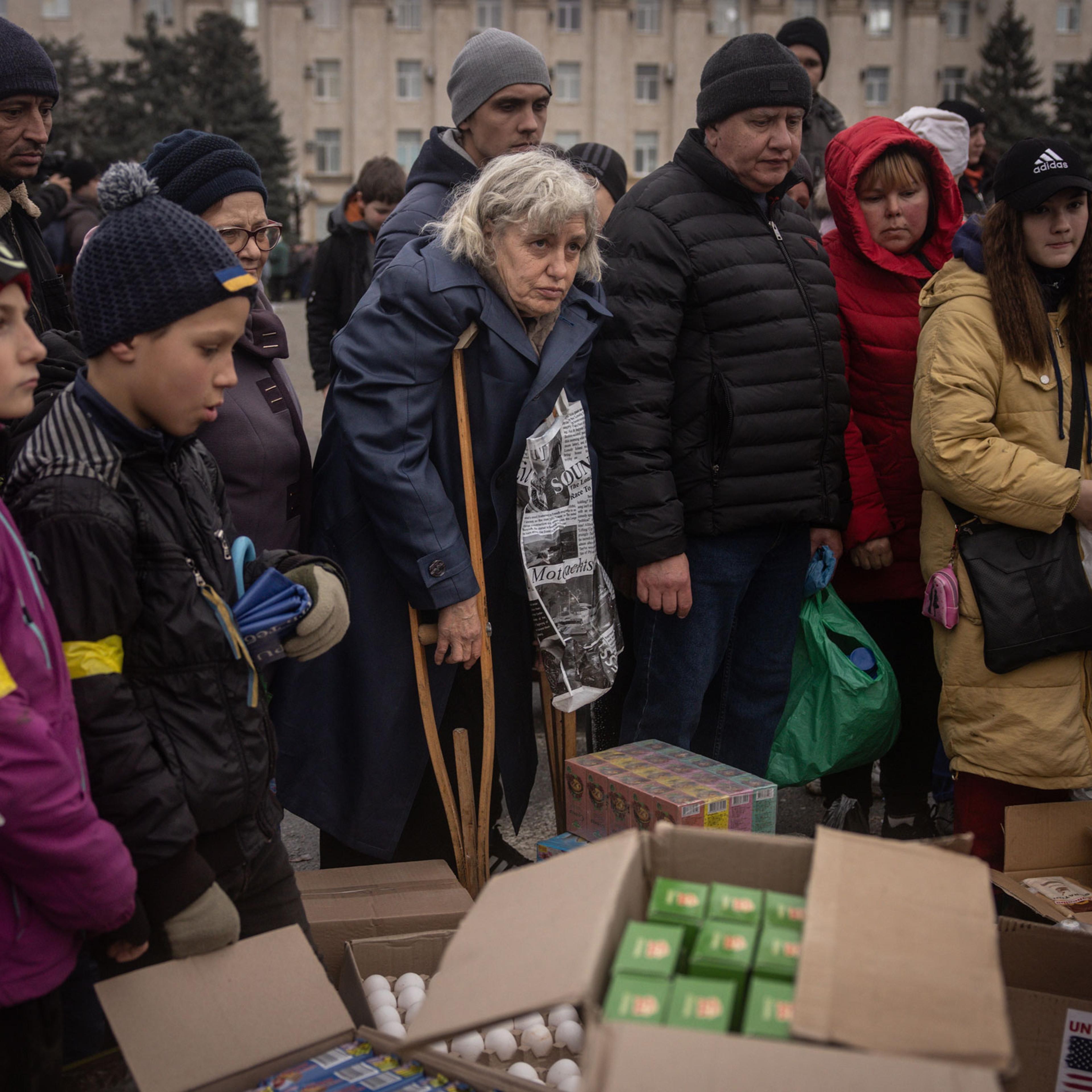 Residents crowd around volunteers to receive humanitarian food aid in Kherson central square on Nov. 20, 2022 in Kherson, Ukraine.