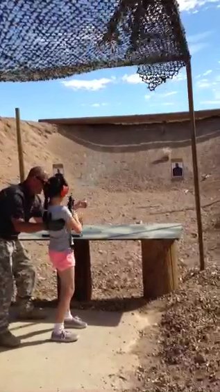 In this video screen capture provided by Mohave County, firing-range instructor Charles Vacca, 39, is seen assisting a 9-year-old girl with an Uzi seconds before the weapon recoiled upwards shooting Vacca in the head, at the Last Stop outdoor shooting ra