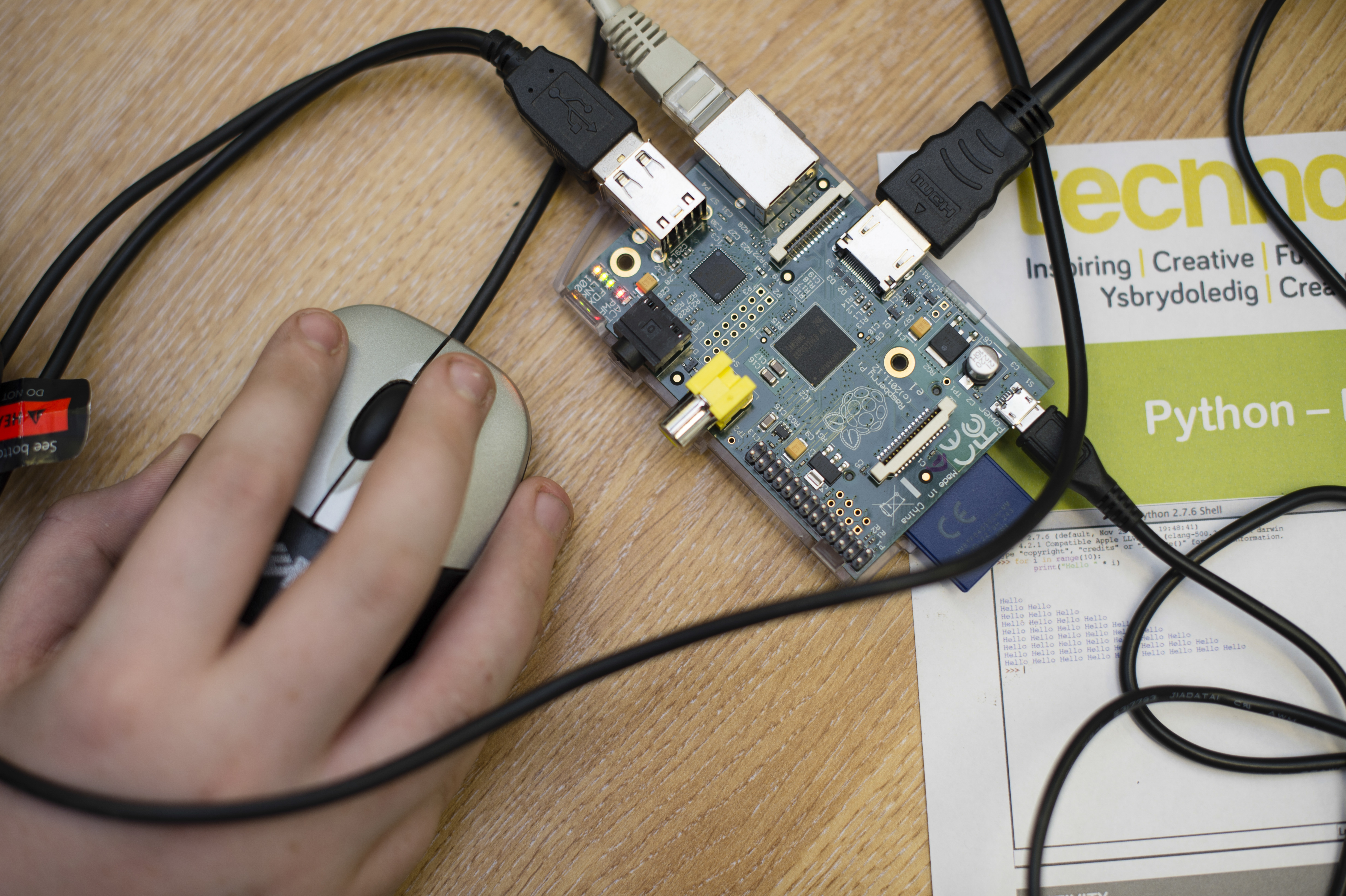 Teenagers at a computer workshop writing code and learning to programme Raspberry Pi simple single-board computer