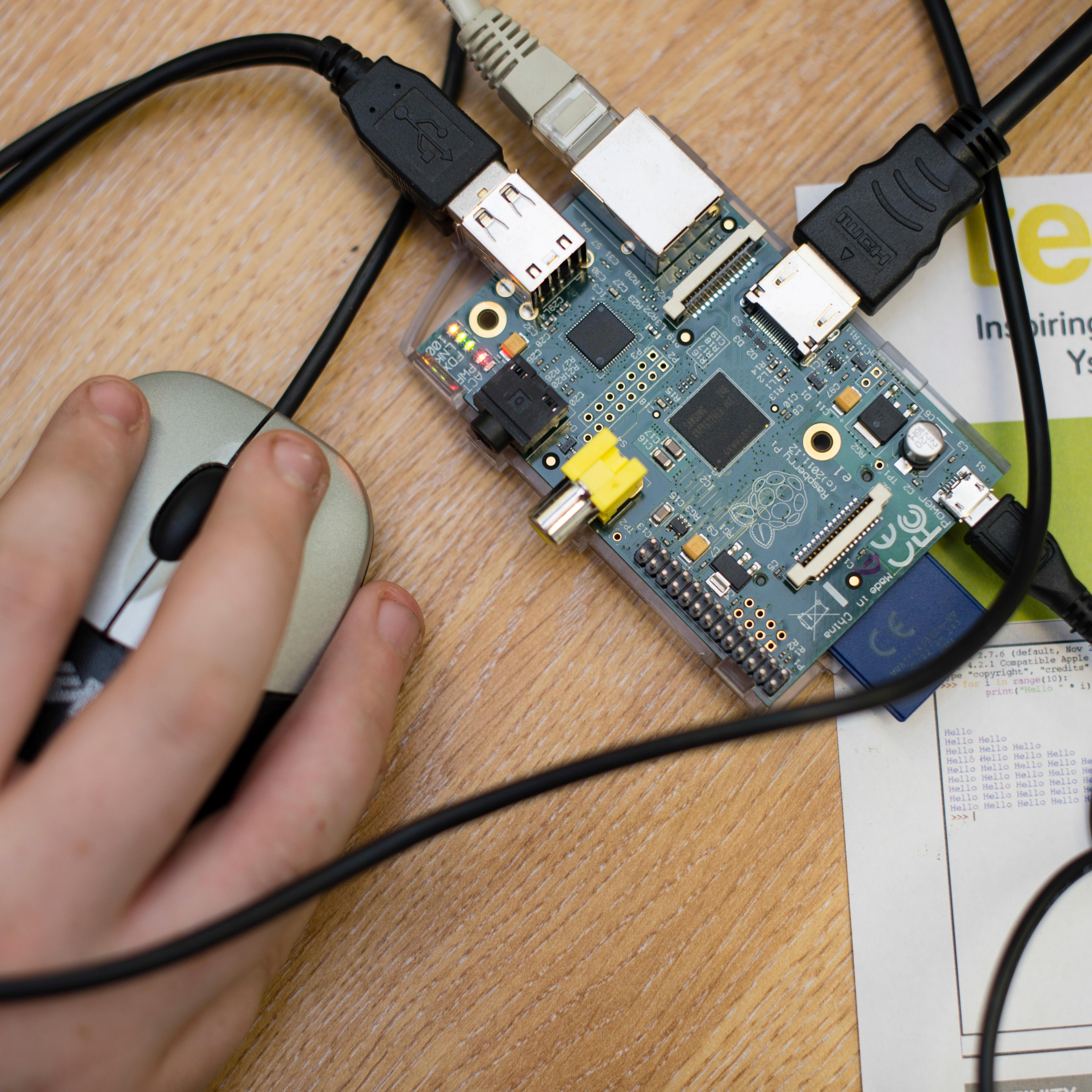 Teenagers at a computer workshop writing code and learning to programme Raspberry Pi simple single-board computer