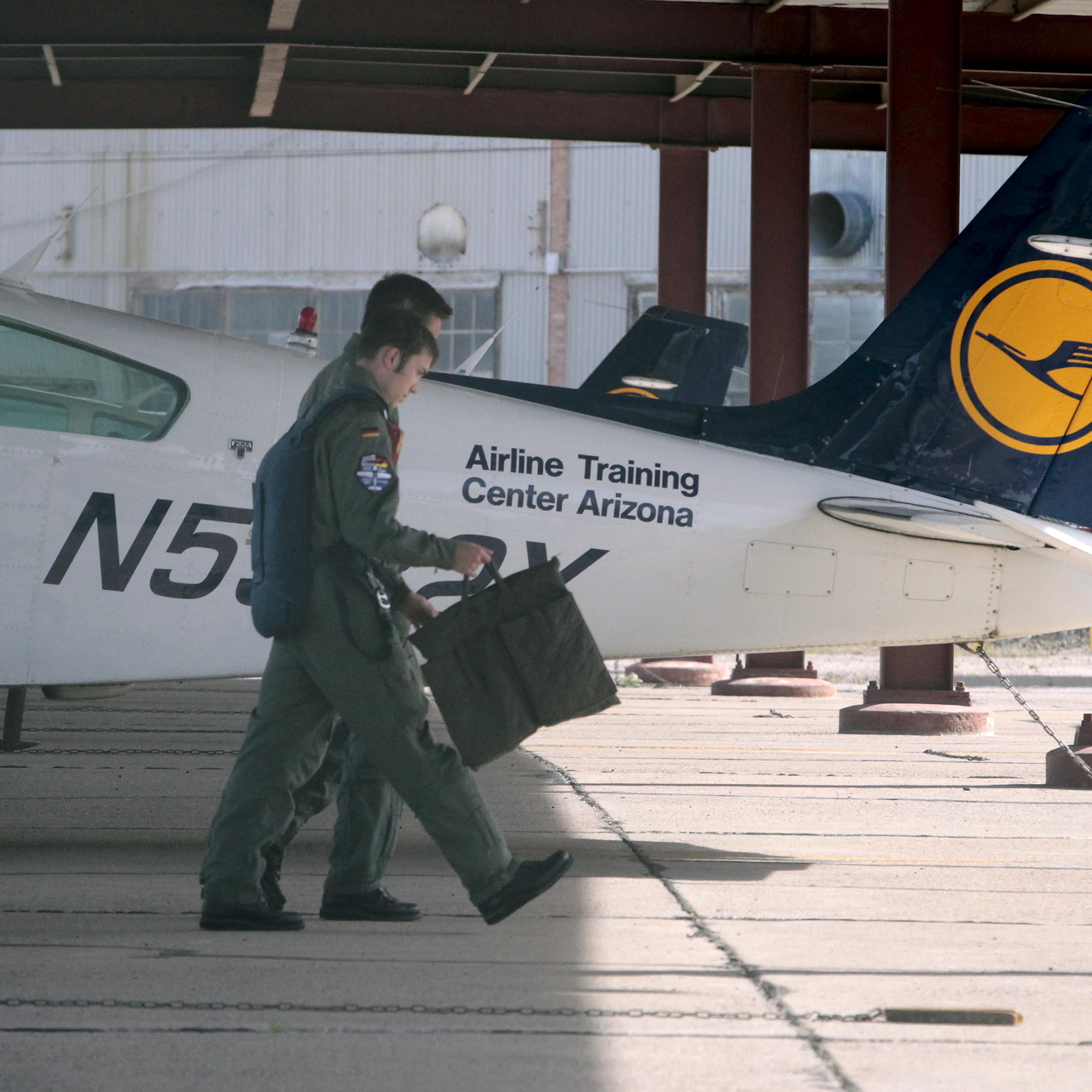 Pilots walk past a light aircraft trainer at the Airline Training Center Arizona in Goodyear, Arizona