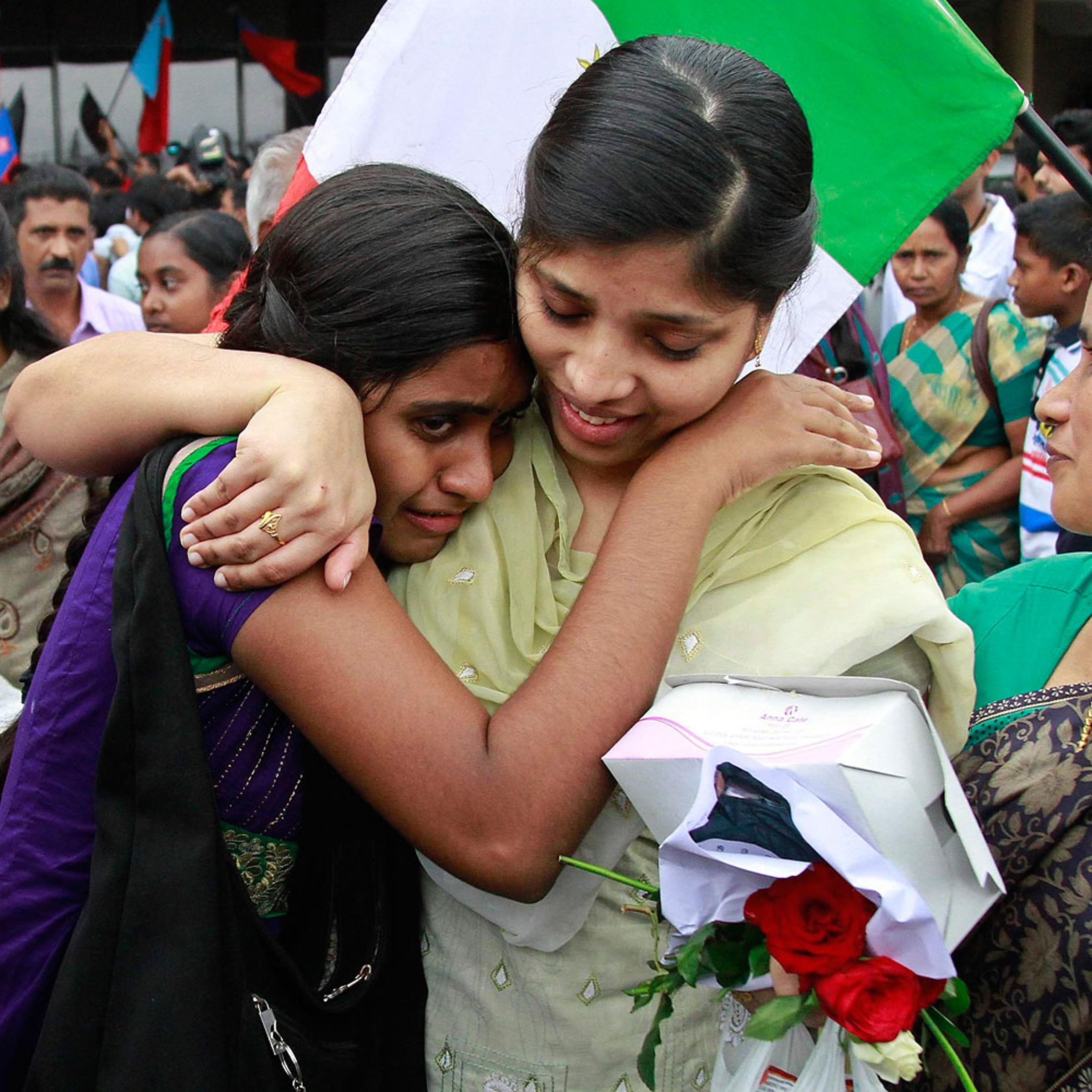 Sherin, an Indian nurse caught up in fighting in Iraq, hugs her sister after arriving at the airport in the southern Indian city of Kochi