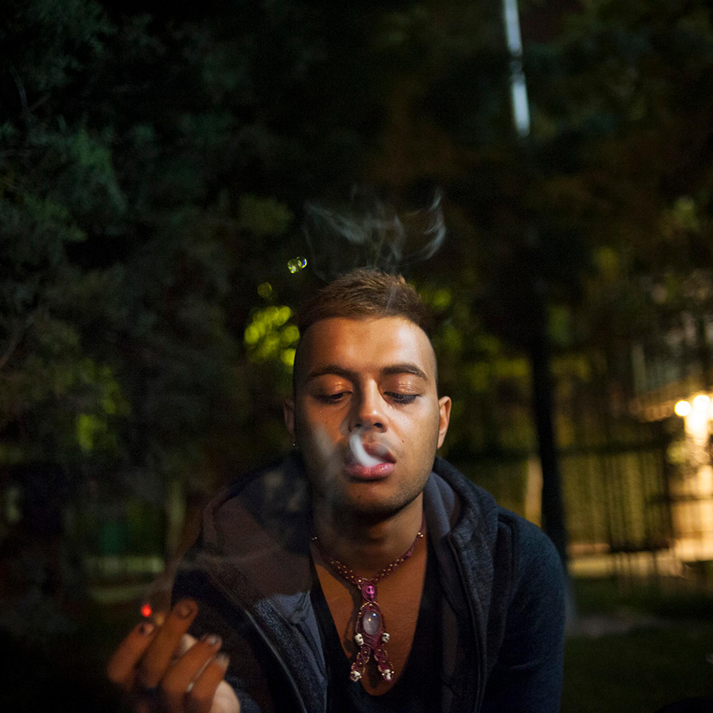 Only a few nights to his departure, Amir hangs out with his friend in a park late at night and smokes a joint to relax. Tehran, Iran.