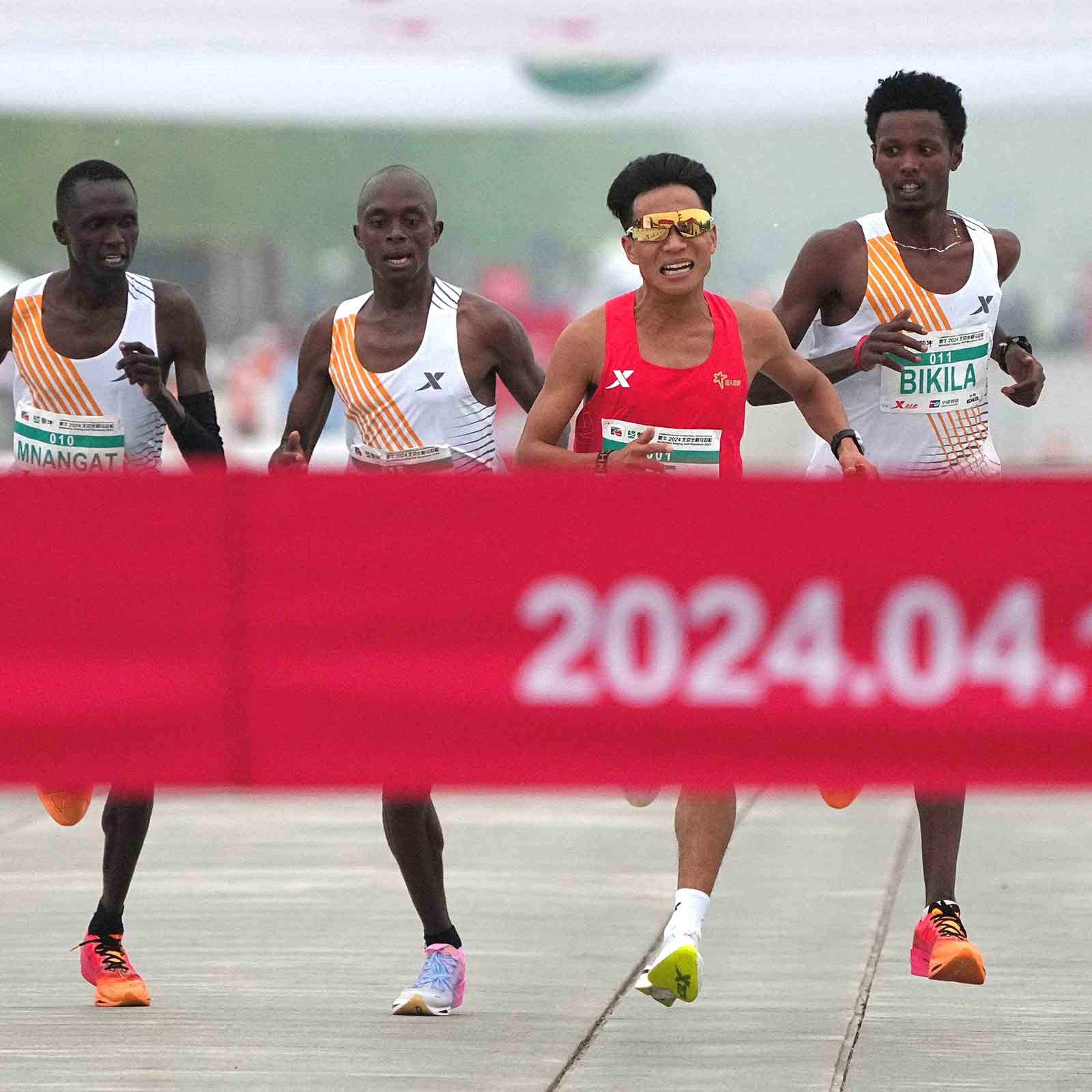 Chinese runner He Jie, Ethiopian Dejene Hailu Bikila, and Kenyans Robert Keter and Willy Mnangat take part in the Beijing Half Marathon on April 14, 2024.