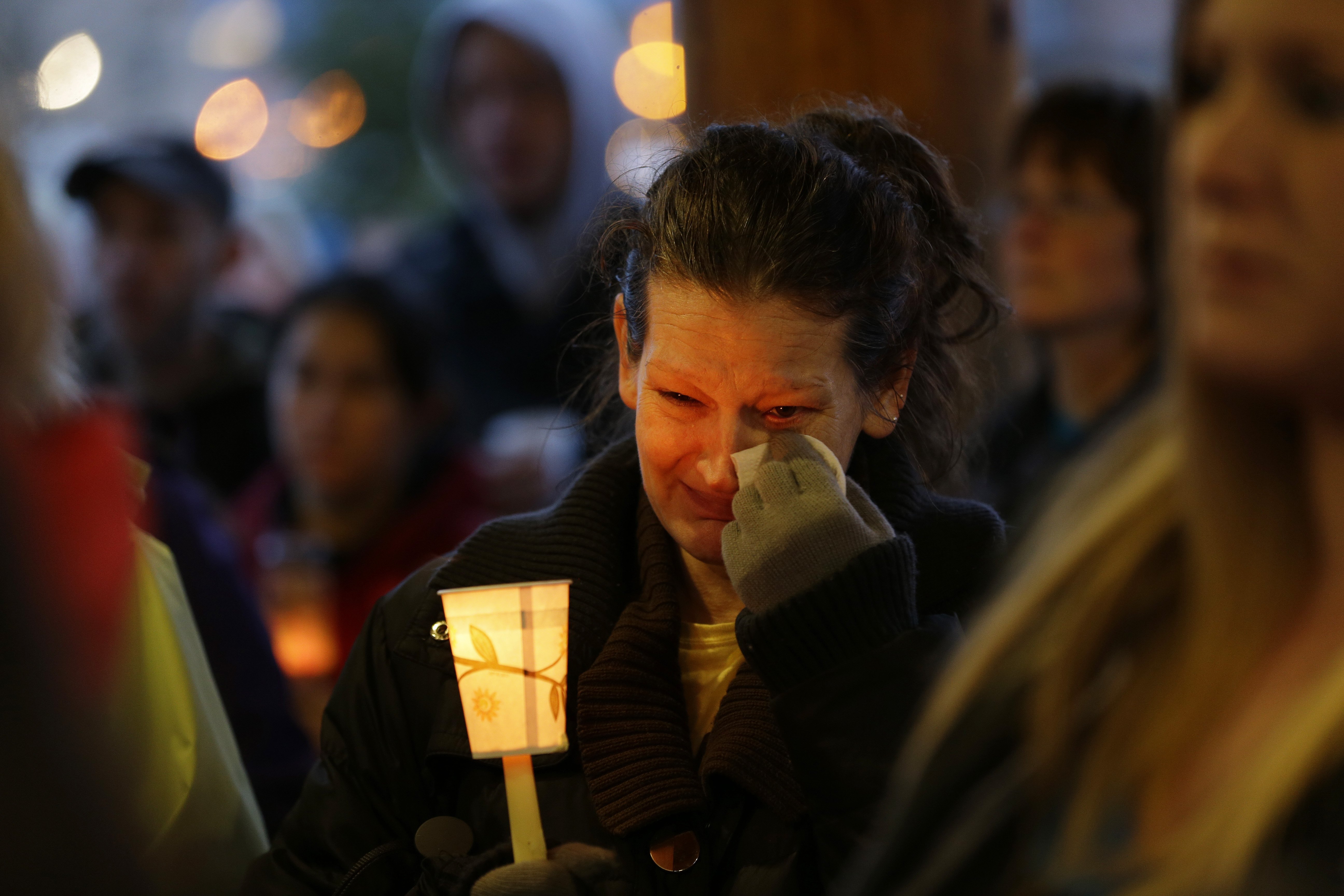 Teresa Welter cries as she holds a candle at a candlelight vigil for the victims of the deadly mudslide in Arlington, Wash., March 25, 2014.