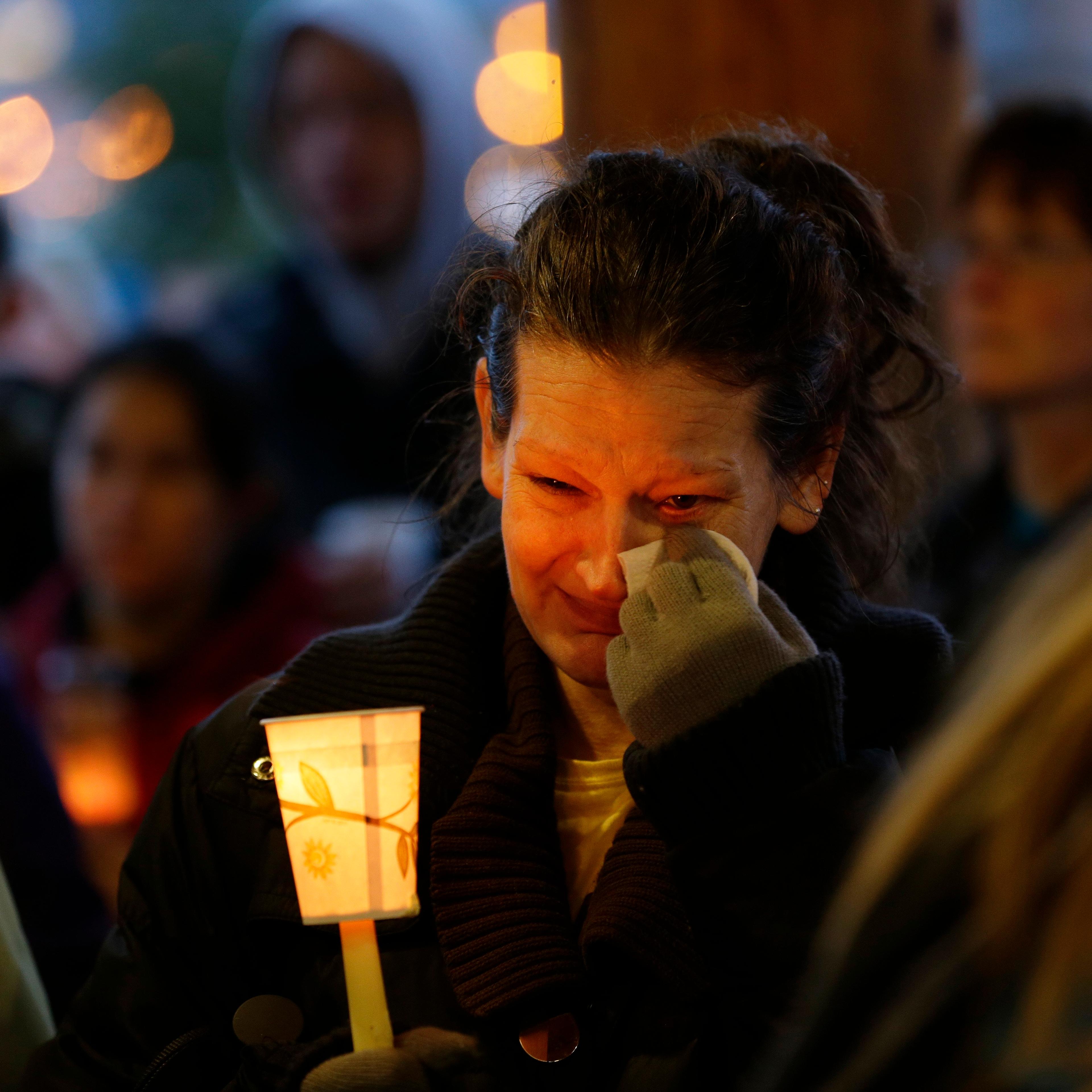 Teresa Welter cries as she holds a candle at a candlelight vigil for the victims of the deadly mudslide in Arlington, Wash., March 25, 2014.