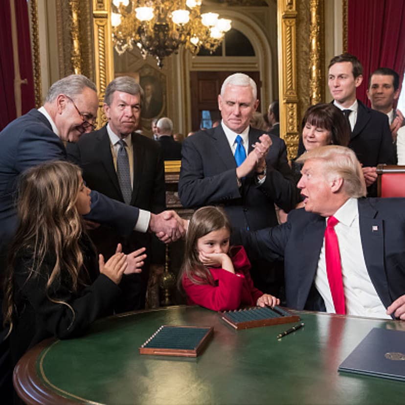 President Donald Trump shakes hands with Senate Minority Leader Chuck Schumer, D-N.Y, as he is joined by the Congressional leadership and his family while he formally signs his cabinet nominations into law, in the President's Room of the Senate, at the C