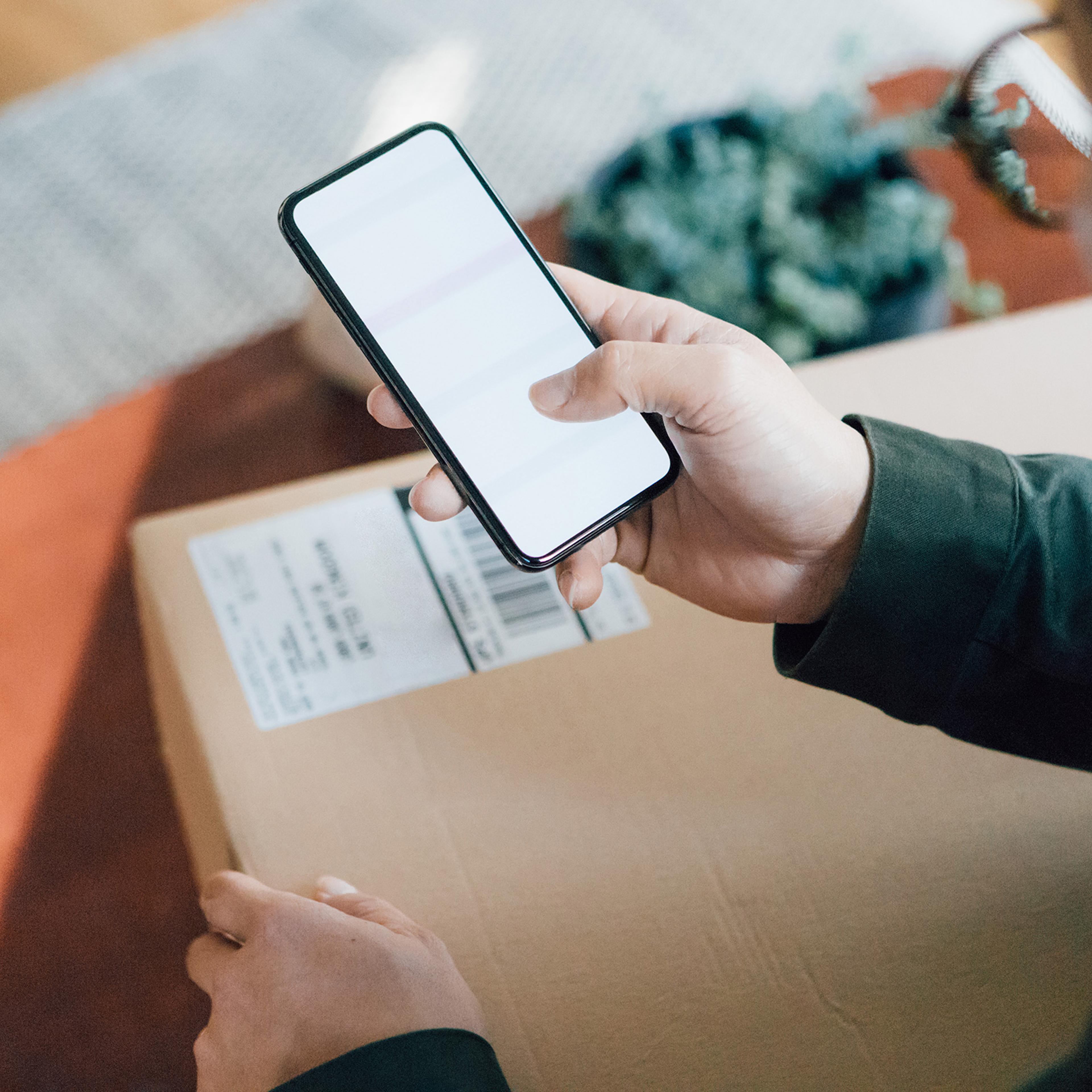 Close up shot of man shopping online with mobile phone at home