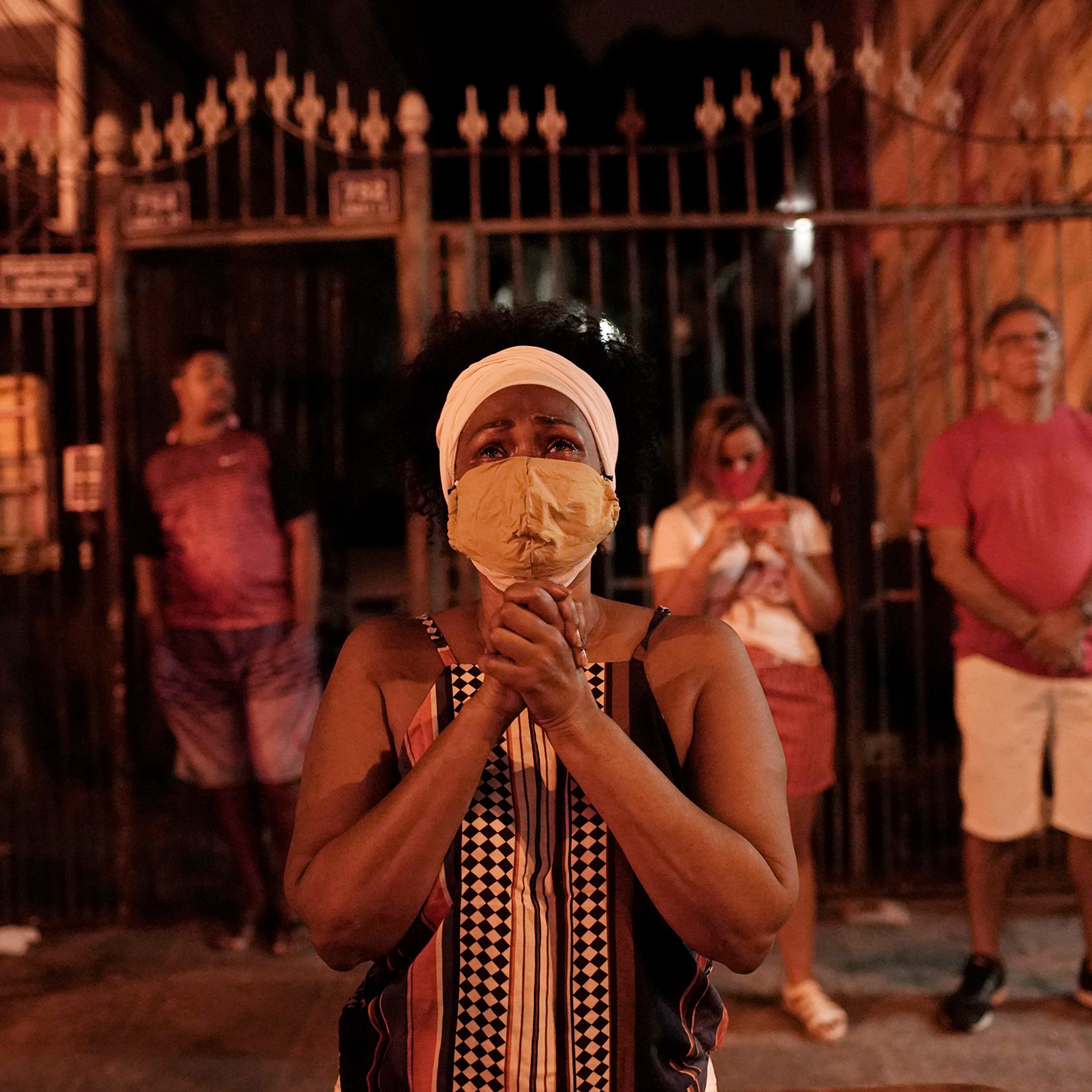 A woman prays outside a closed church in Rio de Janeiro on April 23, a public holiday in Brazil to honor St. George, known for his bravery