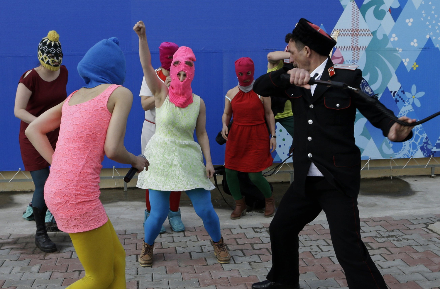 Members of the punk group Pussy Riot, including Nadezhda Tolokonnikova in the blue balaclava and Maria Alekhina in the pink balaclava, are attacked by Cossack militia in Sochi, Russia, on Wednesday, Feb. 19, 2014.