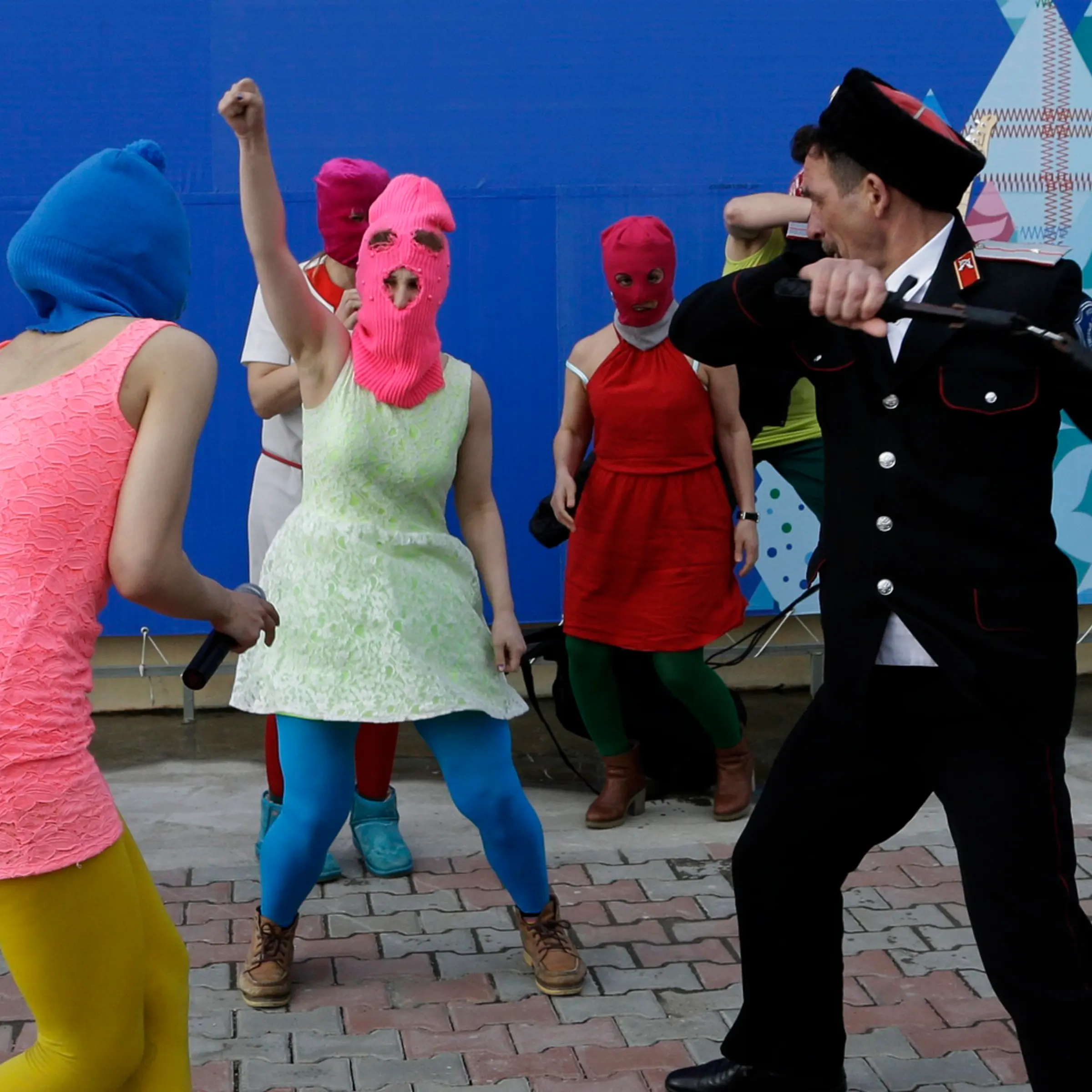 Members of the punk group Pussy Riot, including Nadezhda Tolokonnikova in the blue balaclava and Maria Alekhina in the pink balaclava, are attacked by Cossack militia in Sochi, Russia, on Wednesday, Feb. 19, 2014.