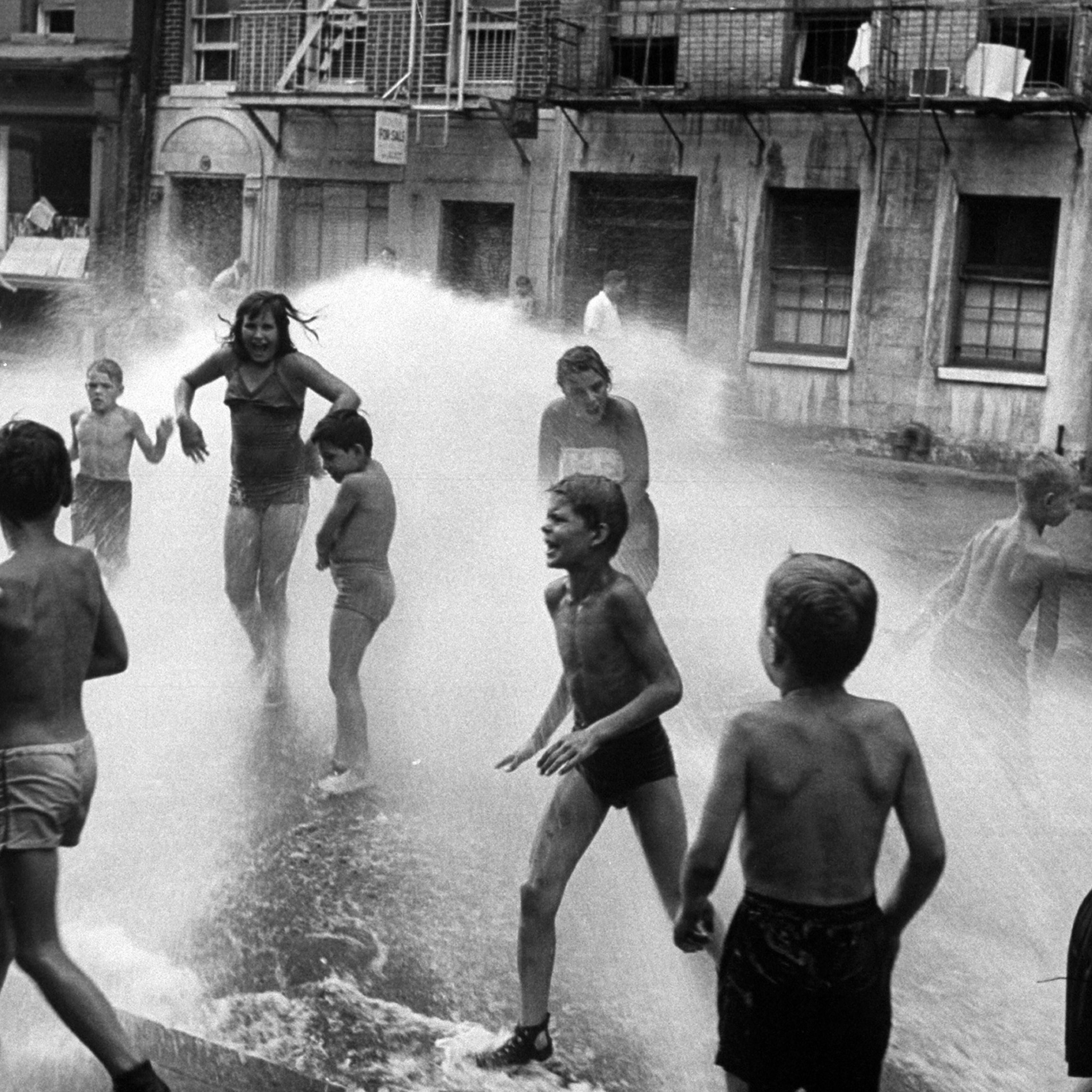 Children playing in water during a heat wave in New York City, 1953.