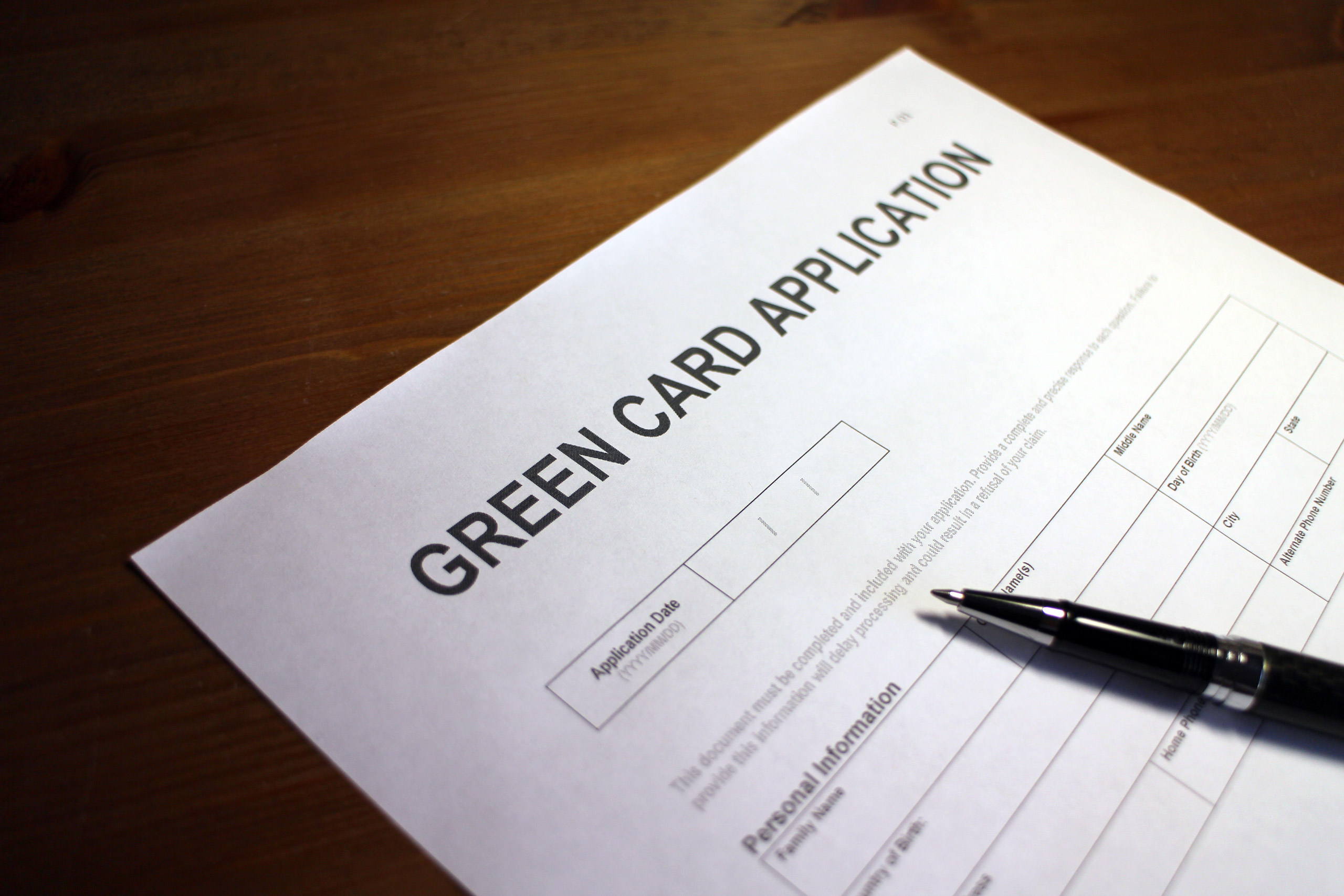 Someone filling out Green Card Application Form.