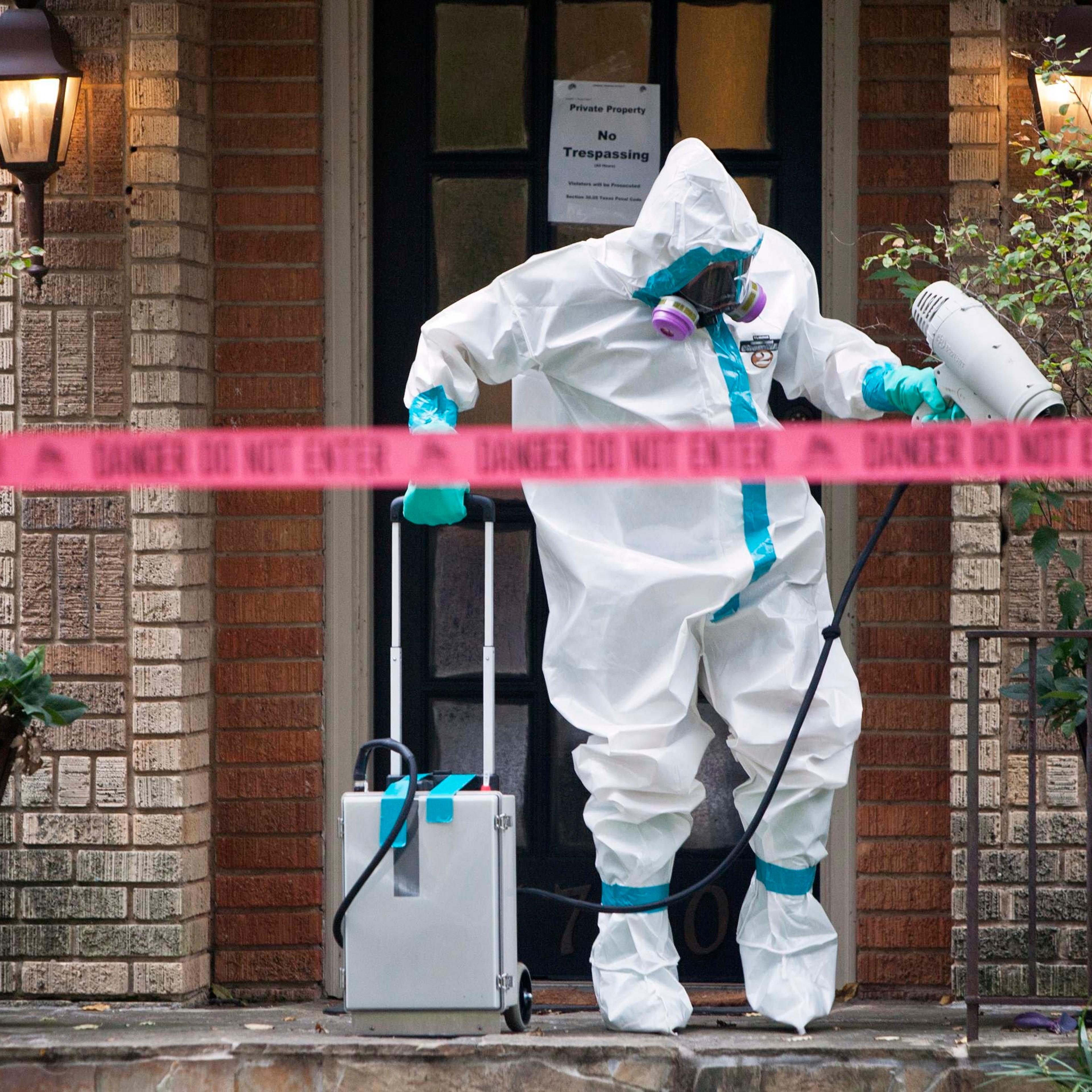 A member of the CG Environmental HazMat team disinfects the entrance to the residence of a health worker at the Texas Health Presbyterian Hospital who has contracted Ebola in Dallas on Oct. 12, 2014.