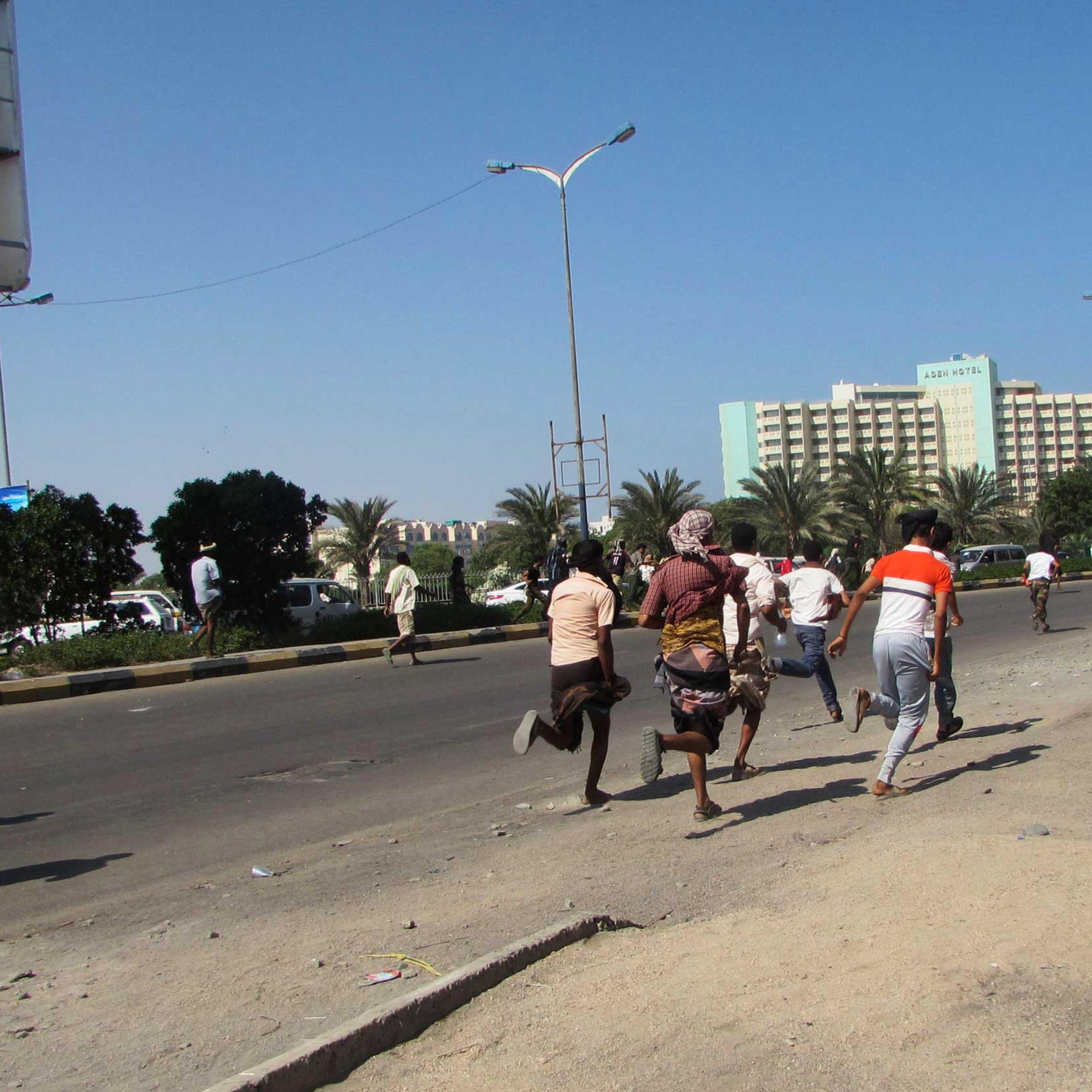 People flee after a gunfire on a street in the southern port city of Aden, Yemen, on March 25, 2015.