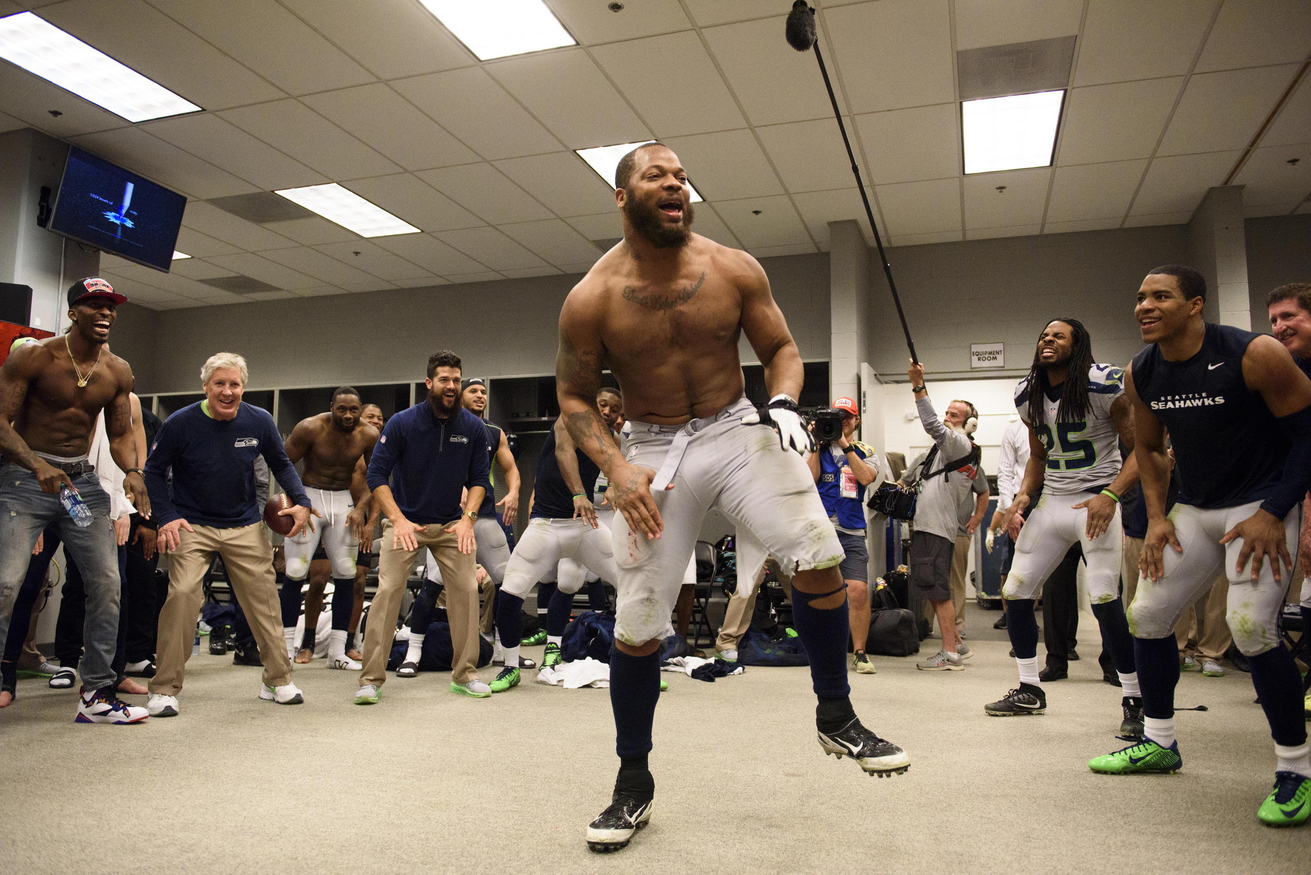 Defensive end Michael Bennett leads the team in the now-traditional post-victory dance in the locker room.