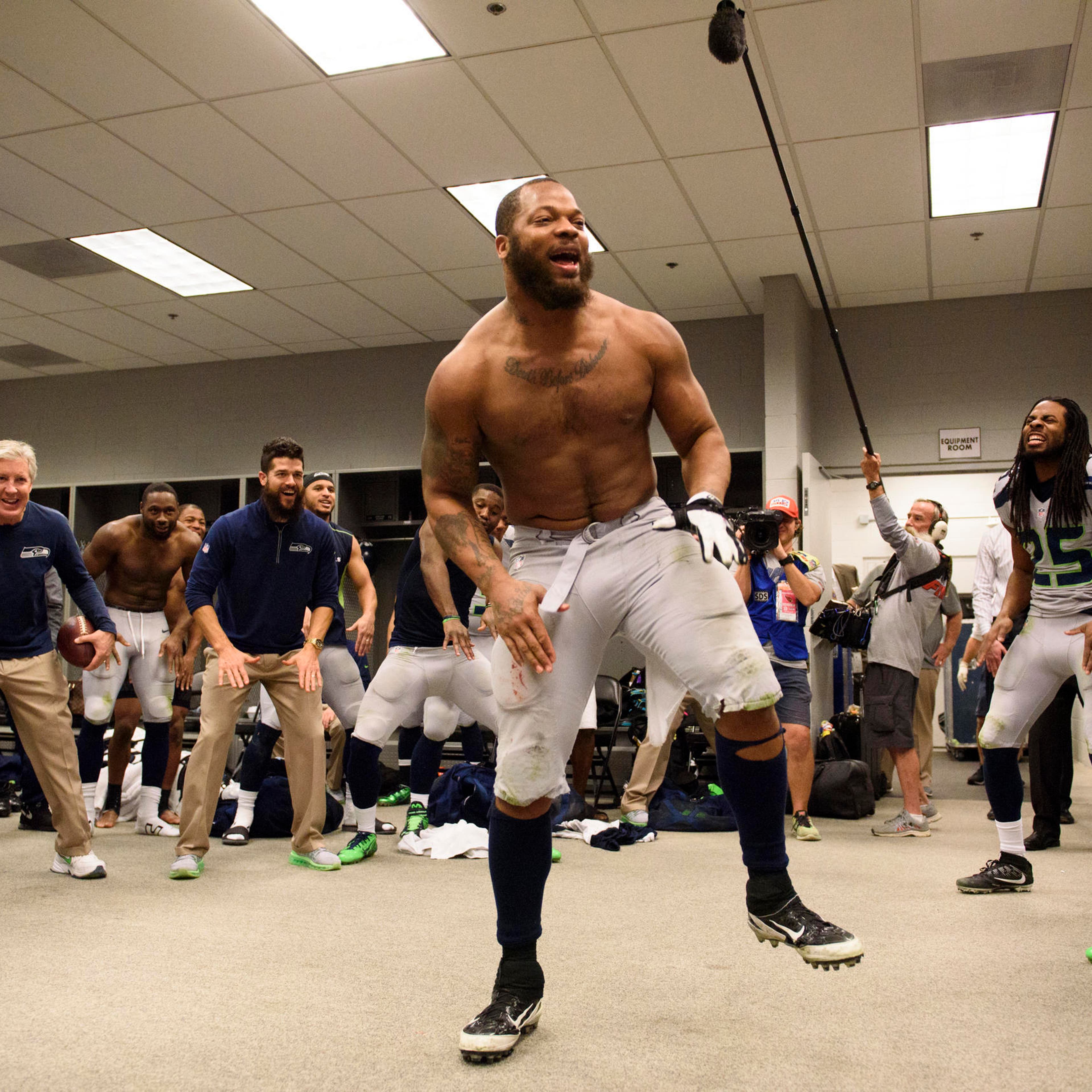 Defensive end Michael Bennett leads the team in the now-traditional post-victory dance in the locker room.