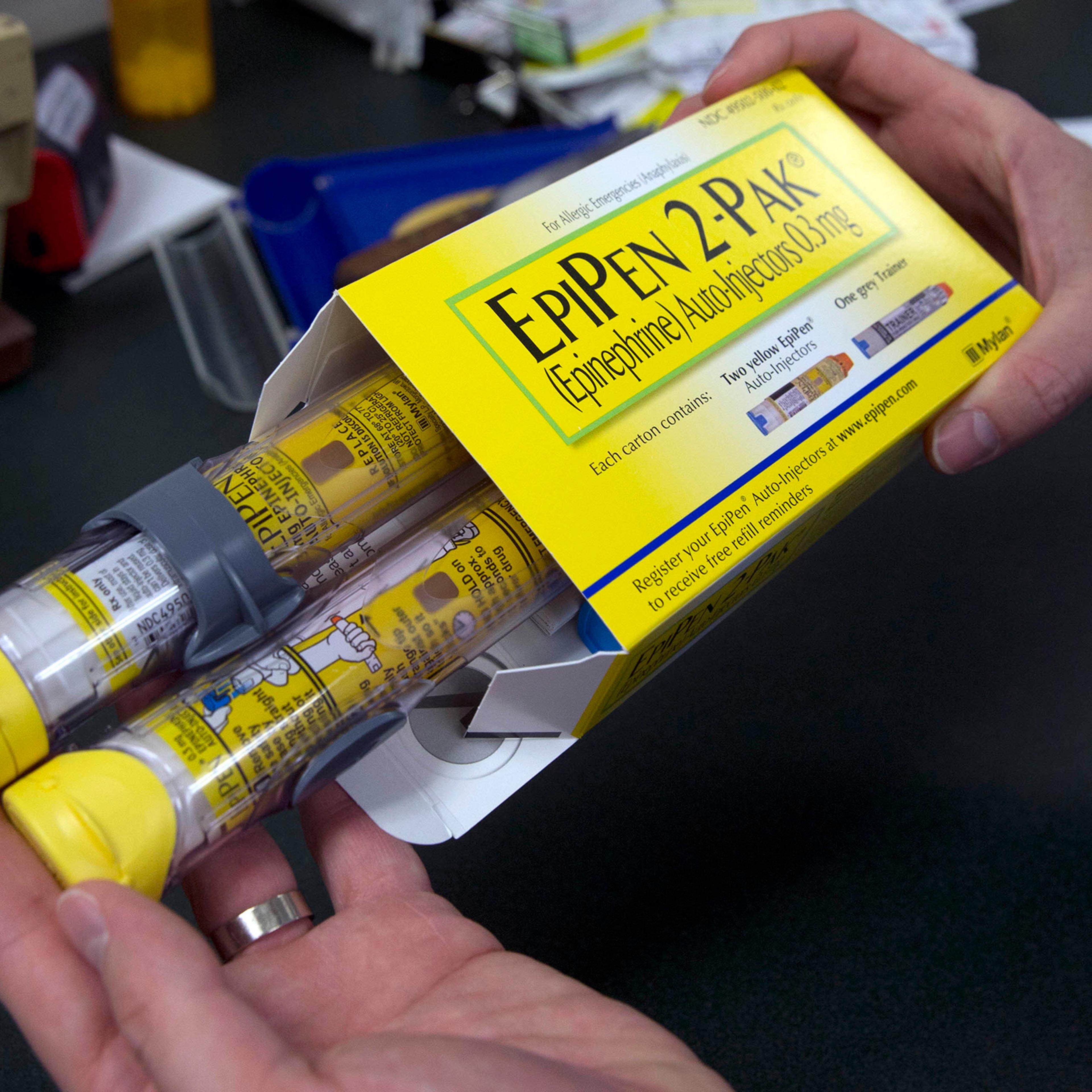 A pharmacist holds a package of EpiPens epinephrine auto-injector, a Mylan product, in Sacramento, Calif. Mylan said it will make available a generic version of its EpiPen, as criticism mounts over the price of its injectable medicine.