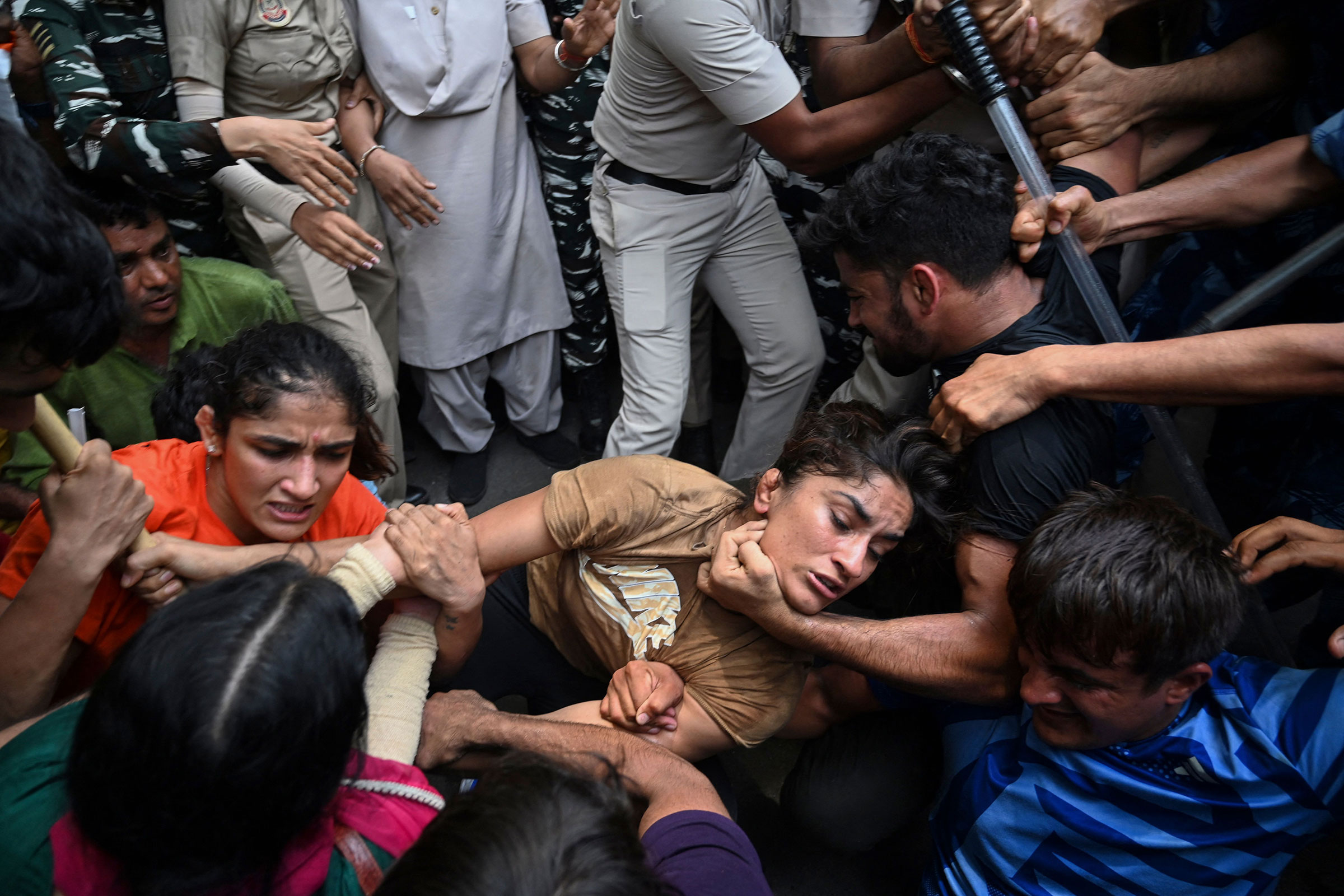 Indian wrestlers Sangeeta Phogat (L), and Vinesh Phogat (C) are detained by the police while attempting to march to India's new parliament, just as it was being inaugurated by Prime Minister Narendra Modi, during a protest against Brij Bhushan Singh, the