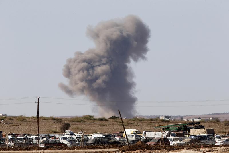 Smoke rises from the Syrian town of Kobani after a war plane carried out an air strike, seen from near the Mursitpinar border crossing on the Turkish-Syrian border in Suruc