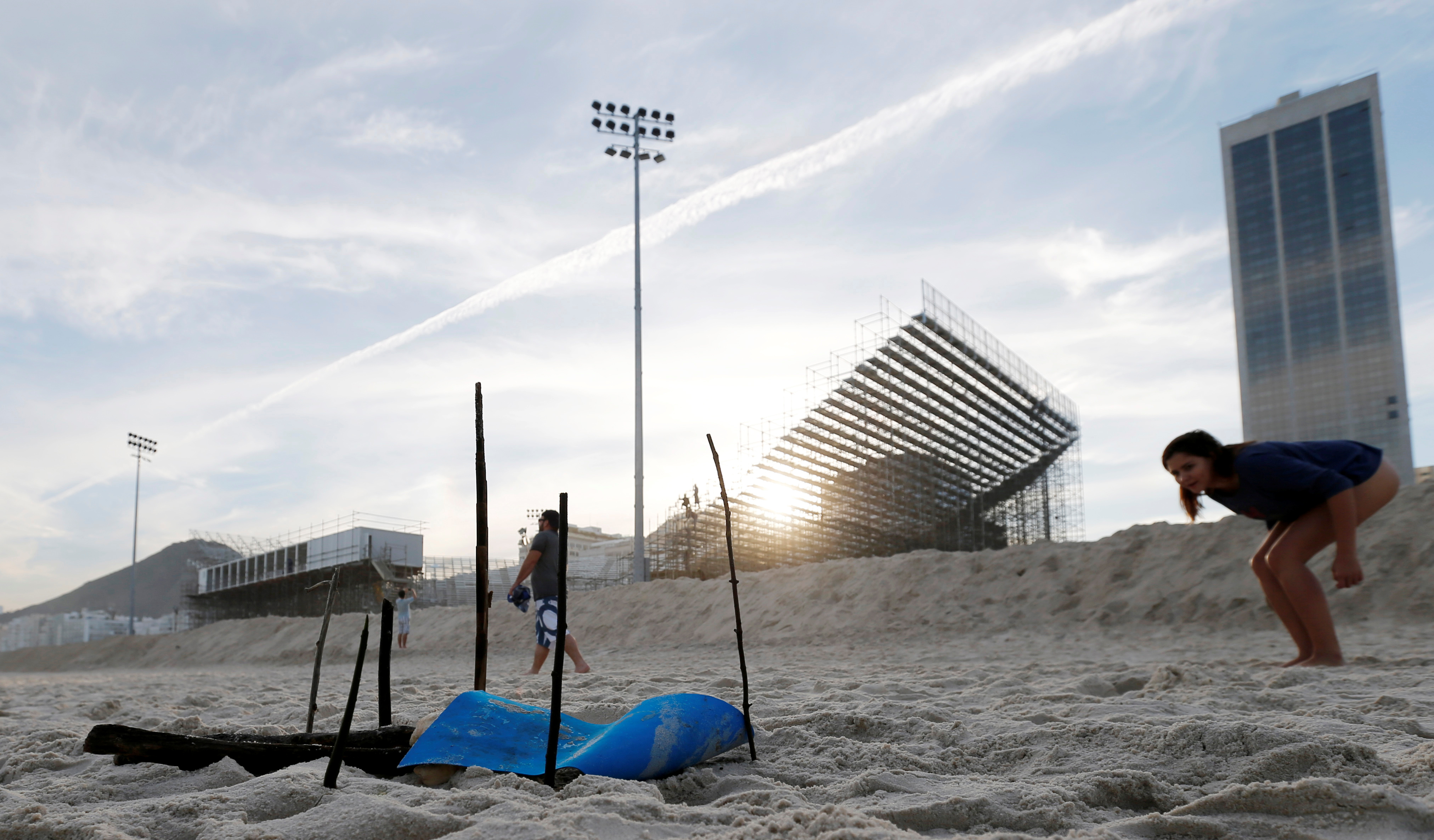 A woman looks at a part of a mutilated body near the construction site of the beach volleyball venue for 2016 Rio Olympics on Copacabana beach in Rio de Janeiro