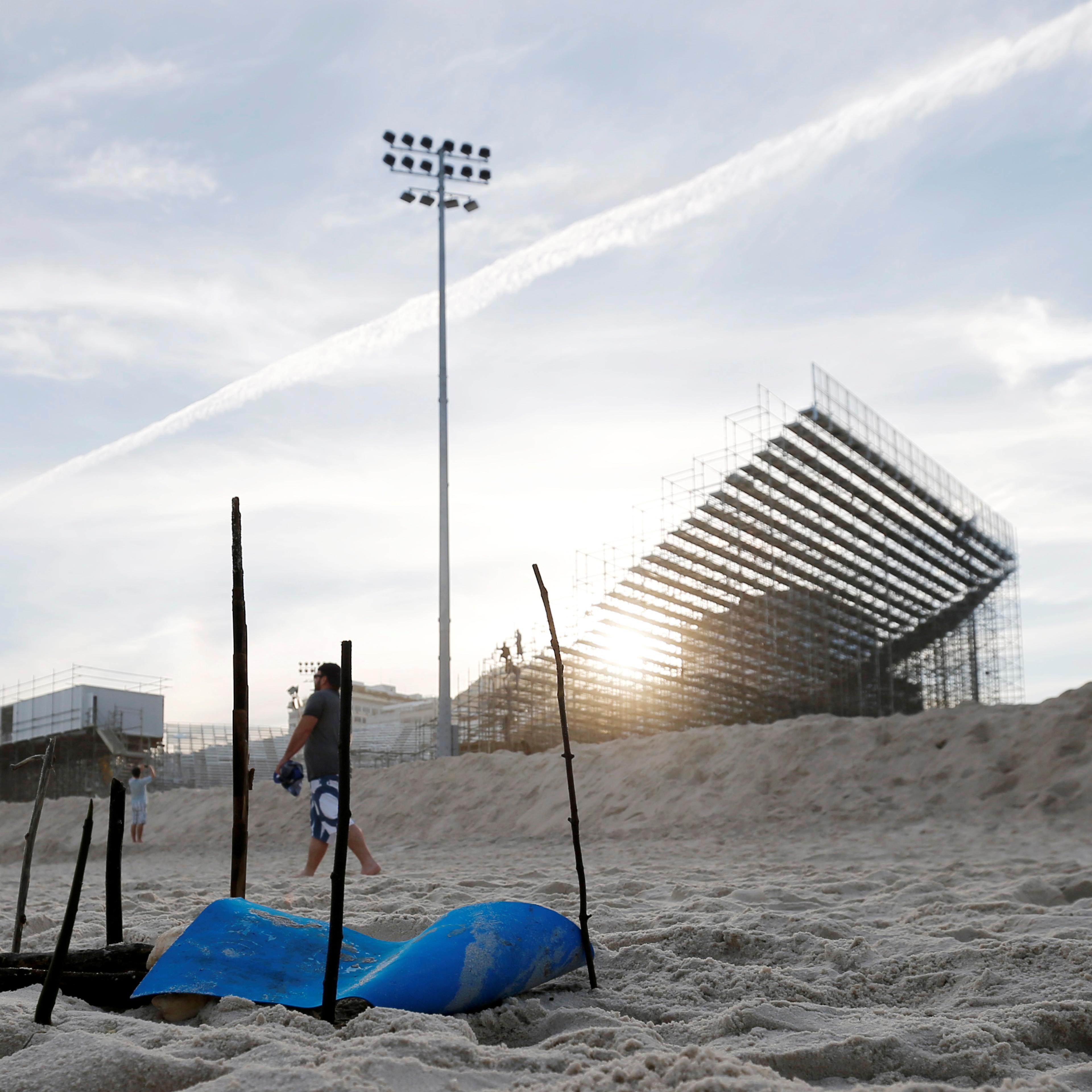 A woman looks at a part of a mutilated body near the construction site of the beach volleyball venue for 2016 Rio Olympics on Copacabana beach in Rio de Janeiro