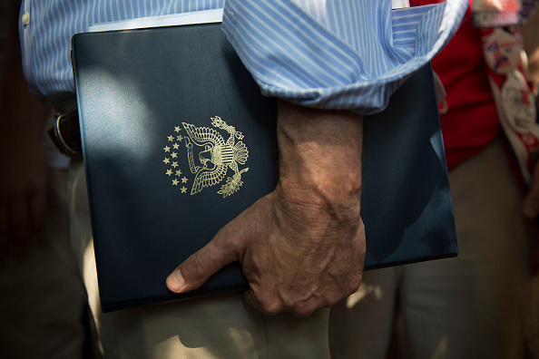 A staffer for Senator Bernie Sanders, an independent from Vermont and 2016 Democratic presidential candidate, stands near Sanders as he speaks to the media at the Iowa State Fair in Des Moines, Iowa, U.S., on Saturday, Aug. 15, 2015.