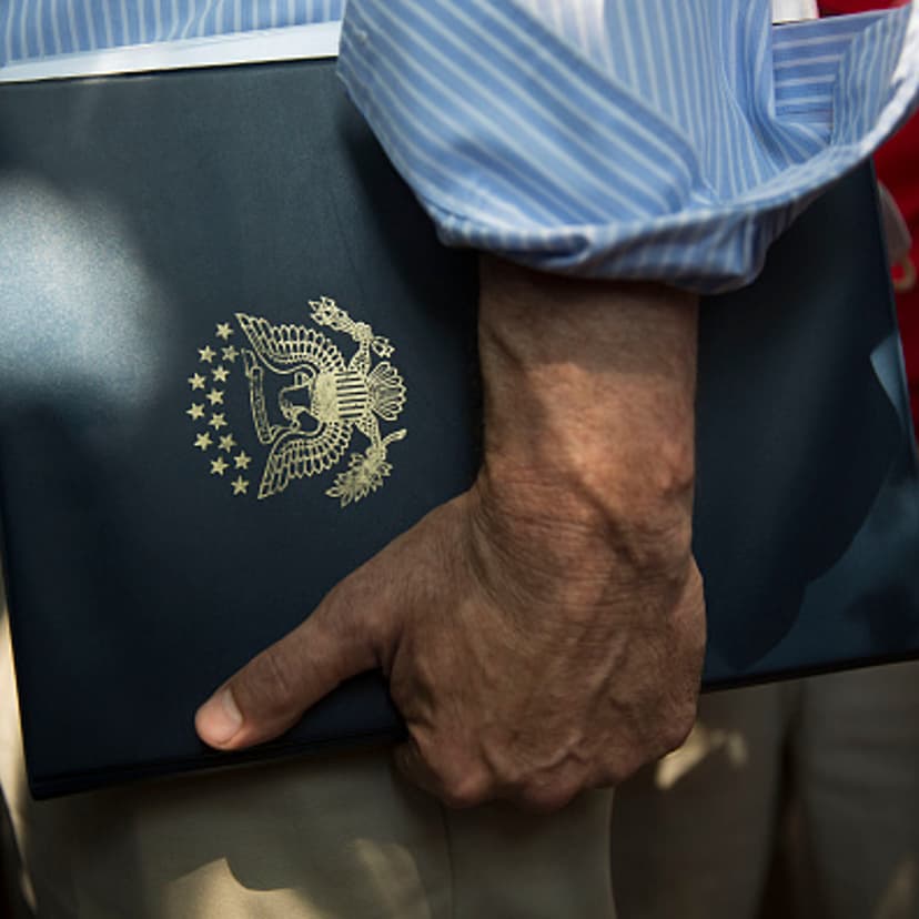 A staffer for Senator Bernie Sanders, an independent from Vermont and 2016 Democratic presidential candidate, stands near Sanders as he speaks to the media at the Iowa State Fair in Des Moines, Iowa, U.S., on Saturday, Aug. 15, 2015.